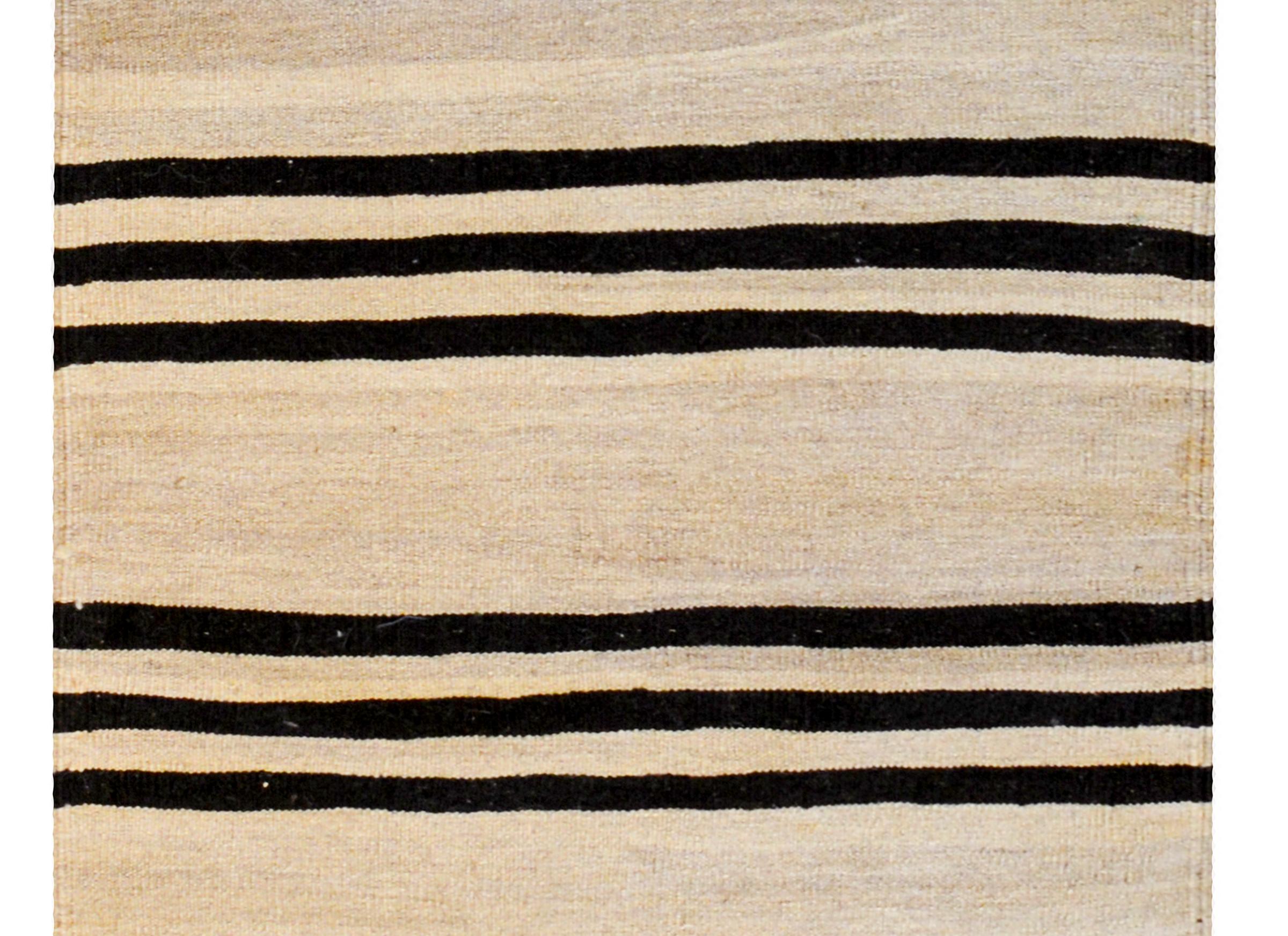 A wonderful early mid-20th century Persian Gabbeh Kilim runner with a bold horizontal stripe pattern with alternating black and natural wool stripes.