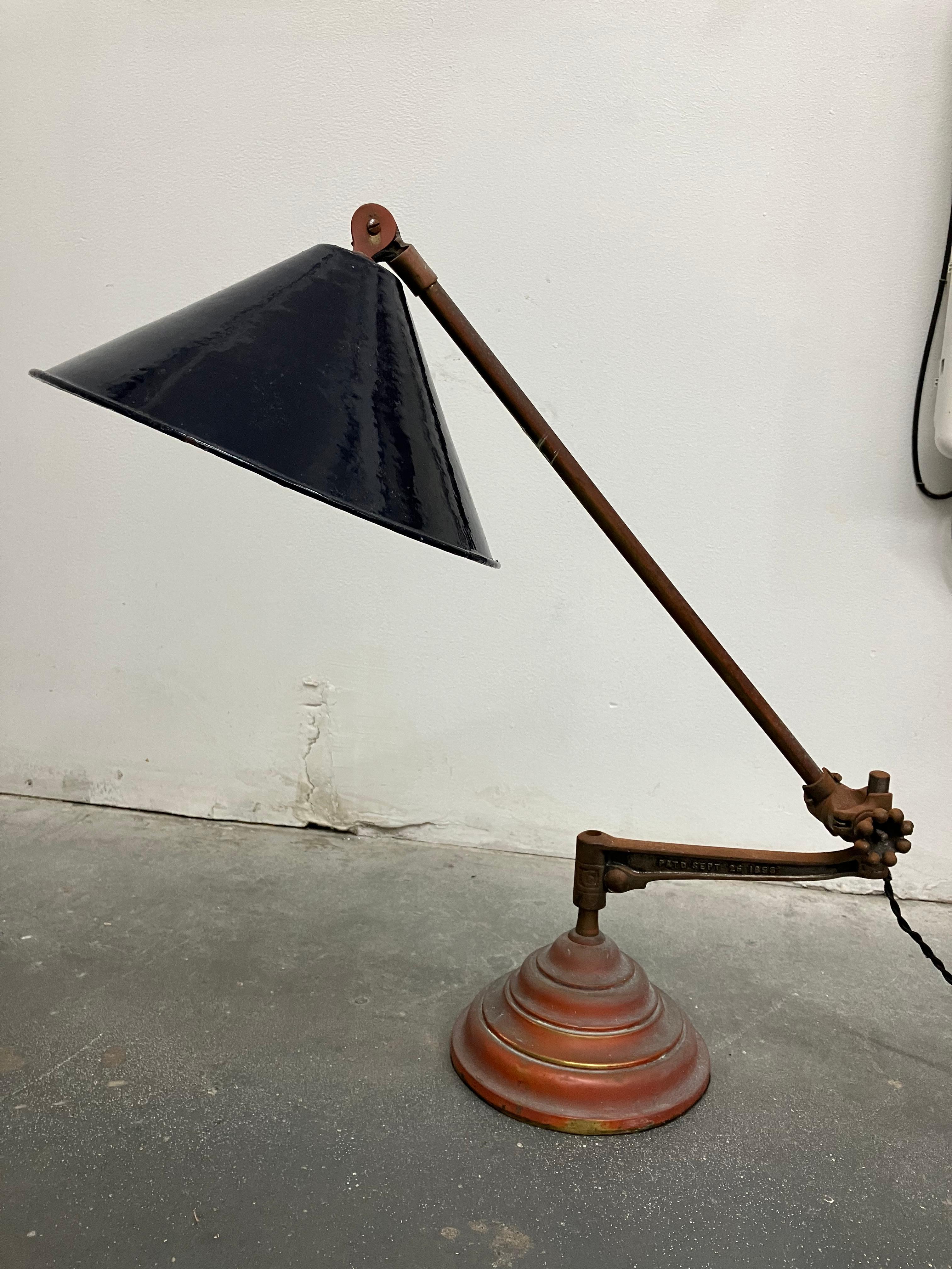 Cobalt blue enameled shade, brass arm and base, and cast iron center arm. Really great combination of materials and style. The pieces can be recombined to make a wall sconce or clamp lamp. Stamped OC White on each piece with an 1889 patent