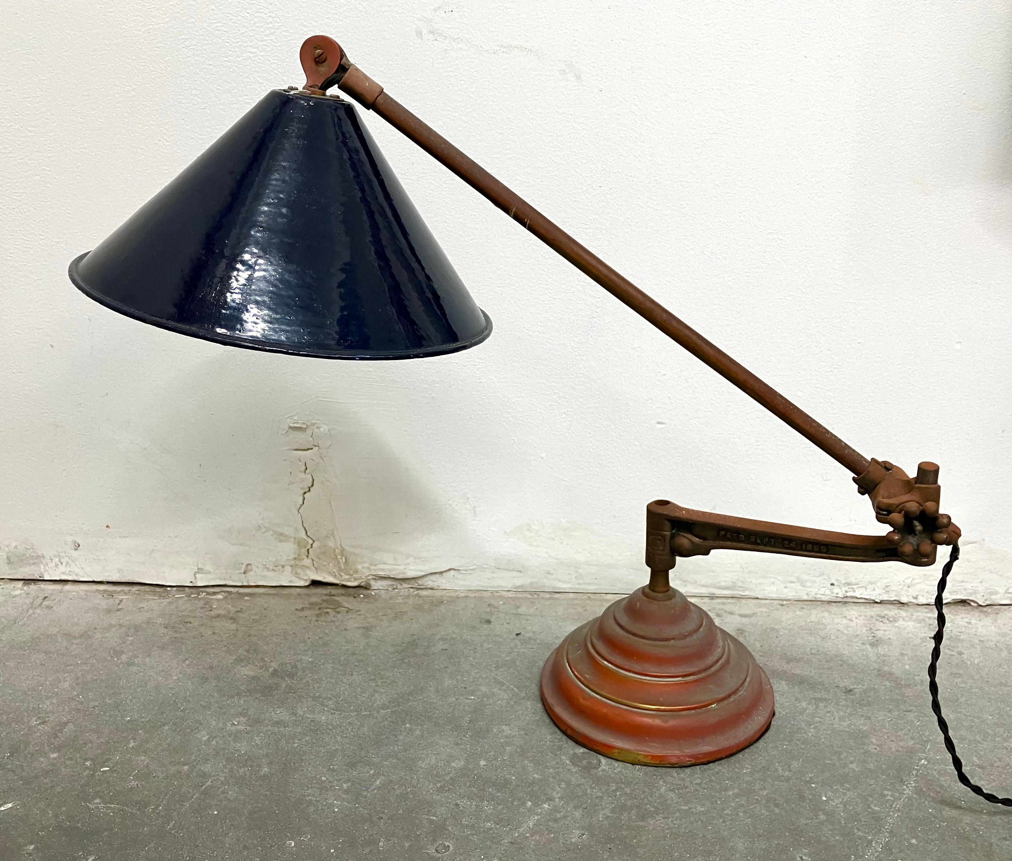 Cobalt blue enameled shade, brass arm and base, and cast iron center arm. Really great combination of materials and style. The pieces can be recombined to make a wall sconce or clamp lamp. Stamped OC White on each piece with an 1889 patent