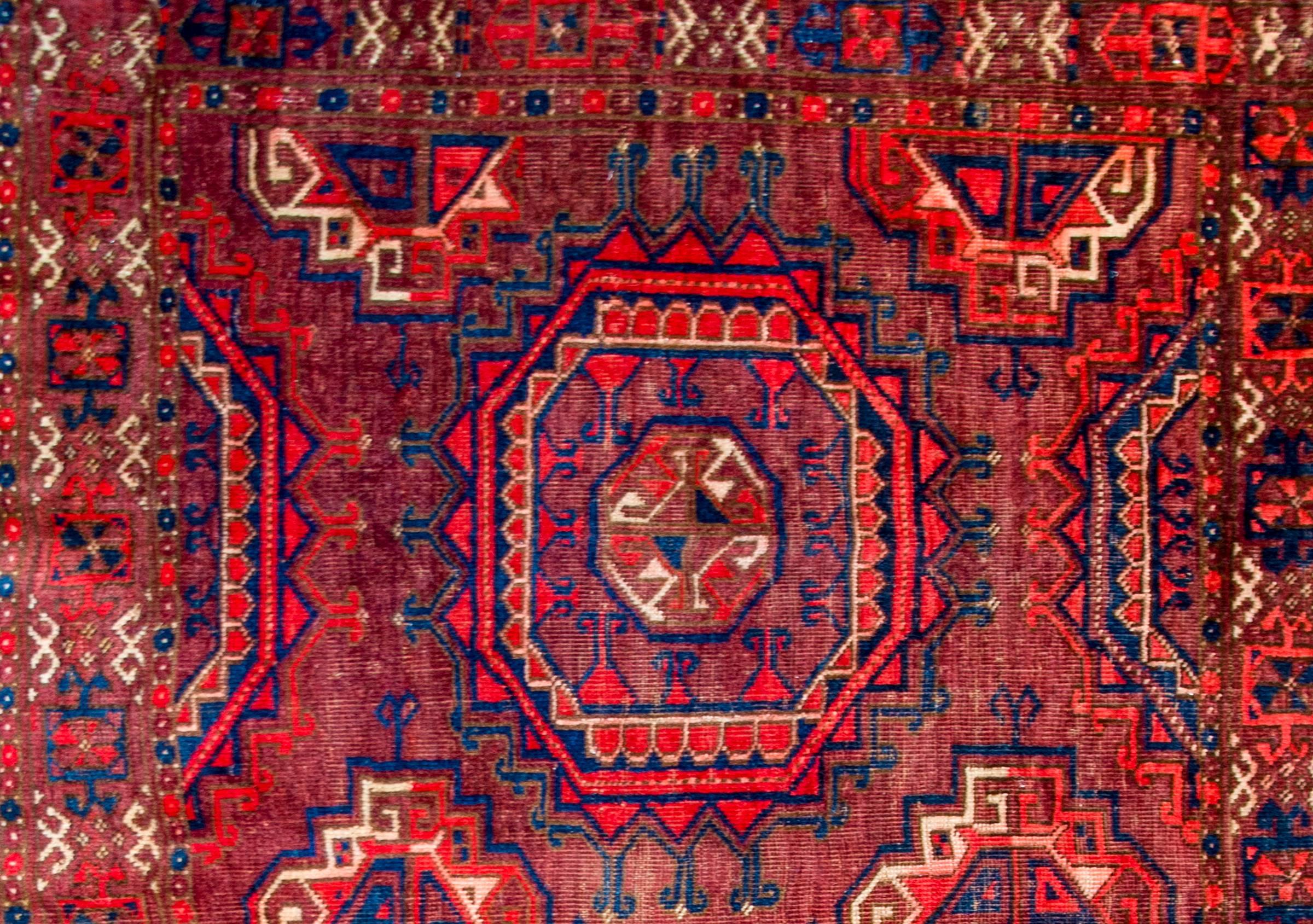 Early 20th century Turkmen Juval bag face with a beautiful pattern containing two large-scale octagonal medallions amidst a field of smaller octagonal medallions all woven in crimon, white, and light and dark indigo, on a crimson background. The
