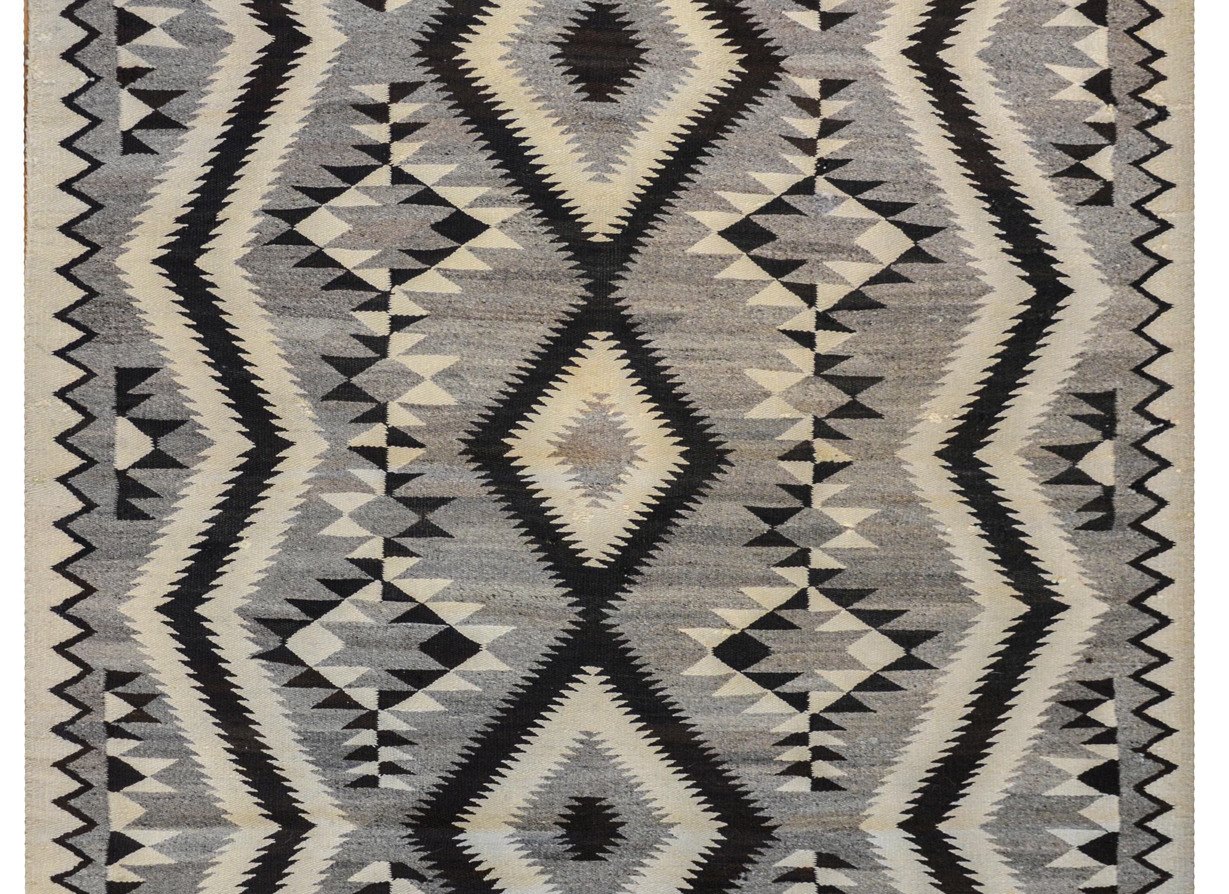 A wonderful early 20th century Navajo rug with an incredible bold black, white, and gray pattern of diamonds and zigzag stripes.