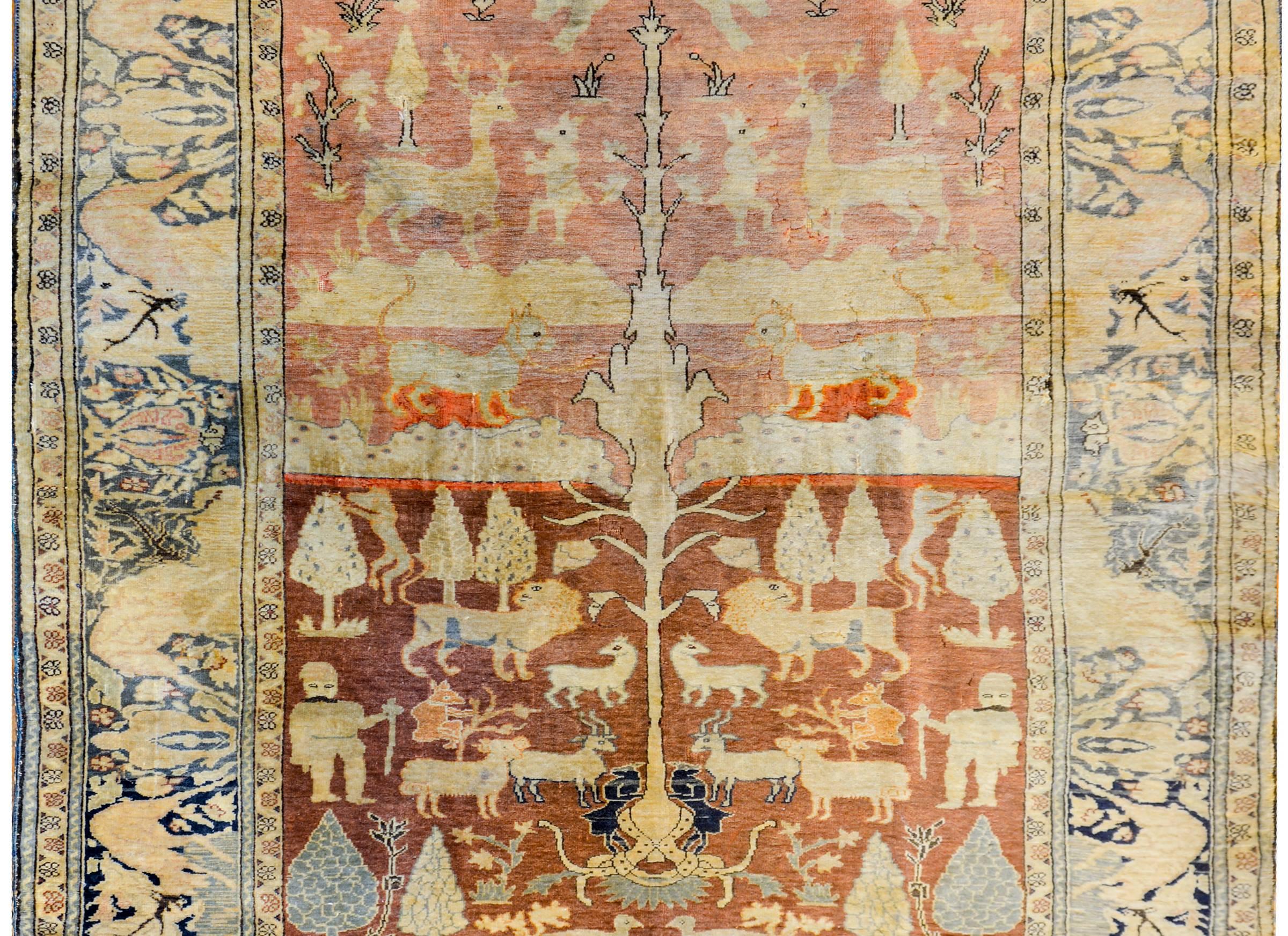 A wonderful early 20th century Turkish Anatolian pictorial rug with a central tree-of-life in a field full or myriad animals including peacocks, lions, goats, dogs, and monkeys, on a sophisticated rusty orange background. The border is also
