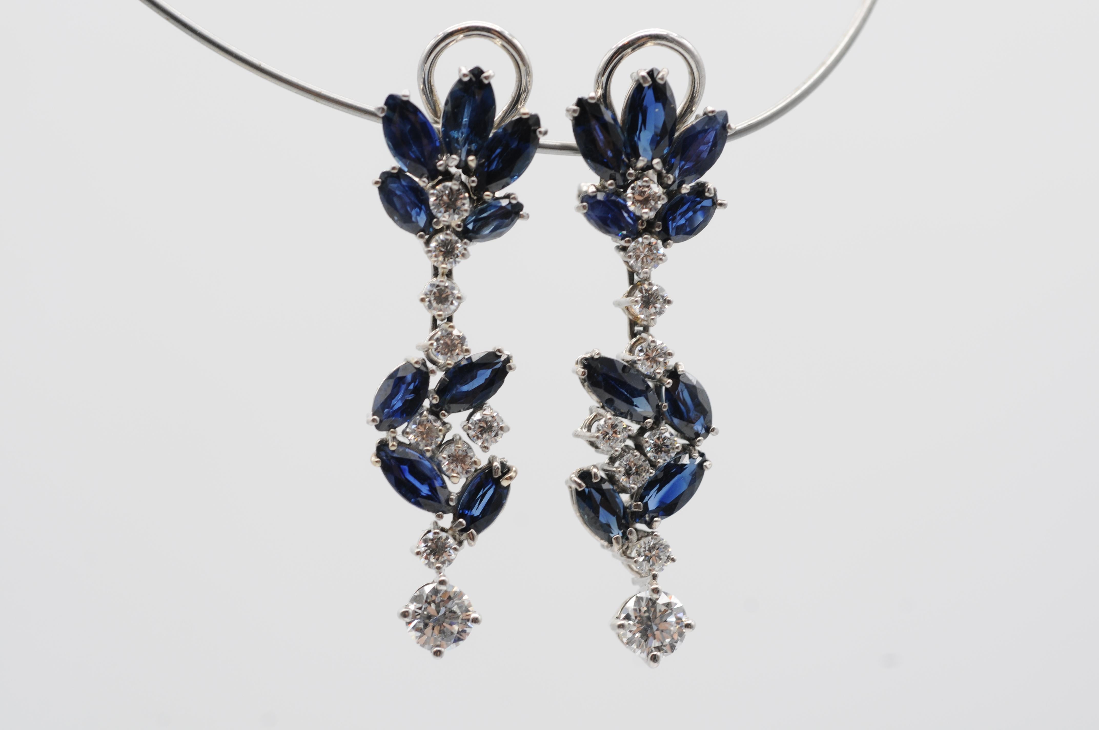Step into the realm of luxury with these majestic 18k white gold drop earrings adorned with sapphires and diamonds. Each side of the earrings features brilliant-cut diamonds totaling approximately 0.72 carats, with a clarity of VS1 and a color grade