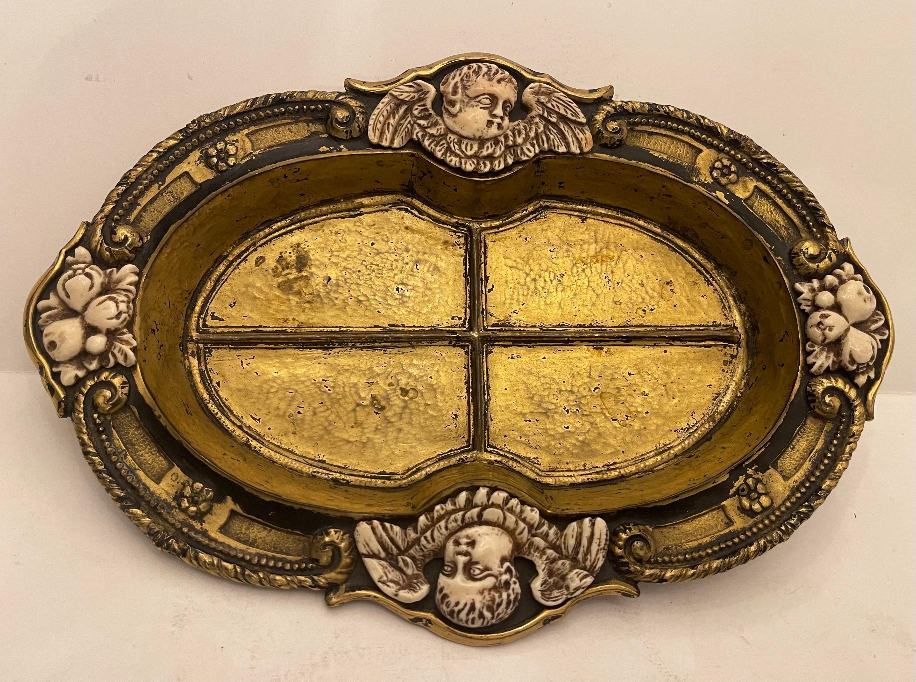Un E. F. A firmado, raro y muy coleccionable Caldwell Bronce Dorado Con Borde Interior Esmaltado En Negro Y Flanqueado Por Un Par De Querubines De Hueso Tallados Y Grupo De Frutas El Cuenco Descansa Sobre Pies Elevados.