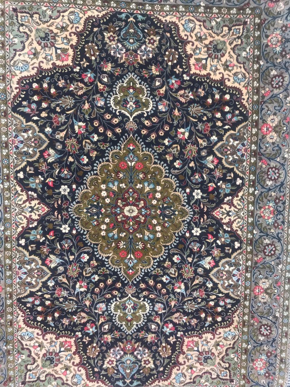 Exquisite fine rug featuring a stunning floral design and a captivating central medallion. This meticulously hand-knotted masterpiece boasts beautiful colors, including shades of blue, green, and pink. Crafted with precision using wool velvet on a