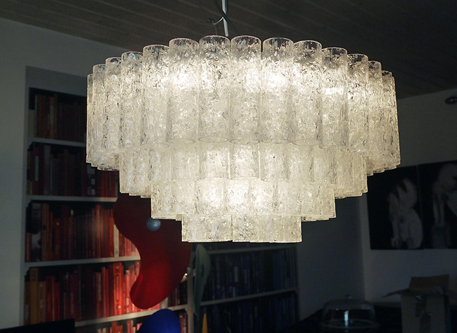 Elegant plafonnier à quatre niveaux avec de nombreux tubes texturés en verre de Murano suspendus à une armature en métal émaillé blanc. Le lustre éclaire magnifiquement et offre beaucoup de lumière. Gemme de l'époque. Avec ce luminaire, vous faites