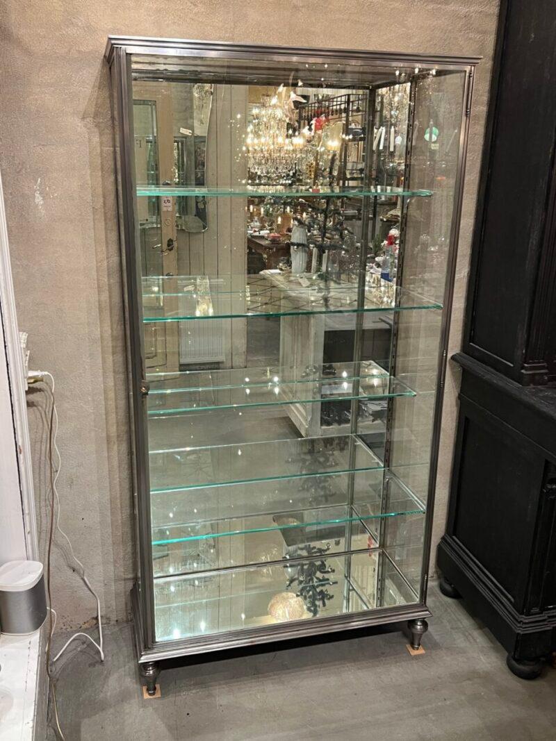 Handsome art deco display cabinet, in quality nickel-plated brass, from France circa 1930s.

This practical and stylish vitrine rests beautifully on elegant legs, and is equipped with mirrored glass on the back and base, as well as 4 glass shelves