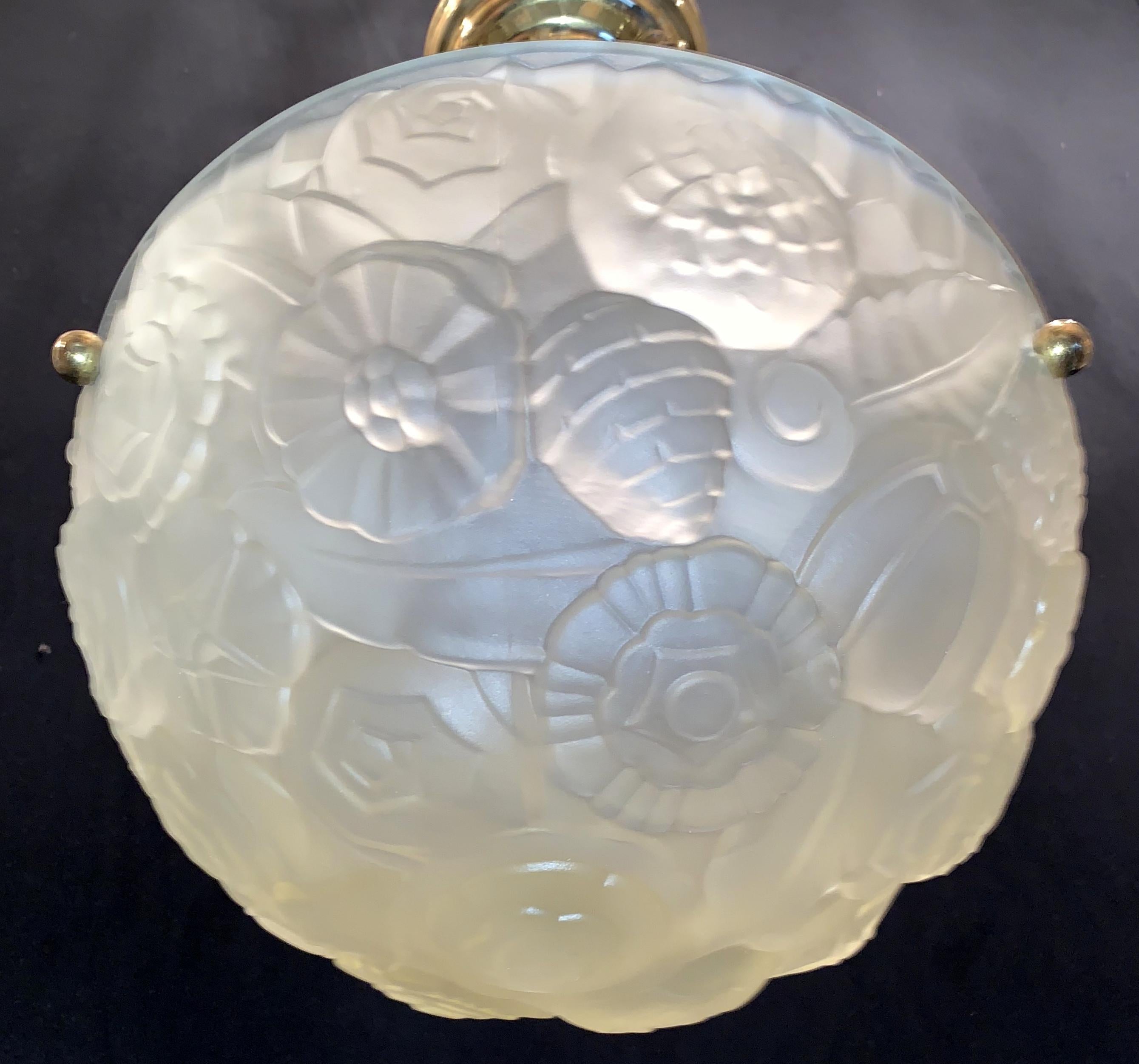 A wonderful French Art Deco frosted faint yellow tone floral design glass brass hardware chandelier 3-light fixture in the manner of Degué.