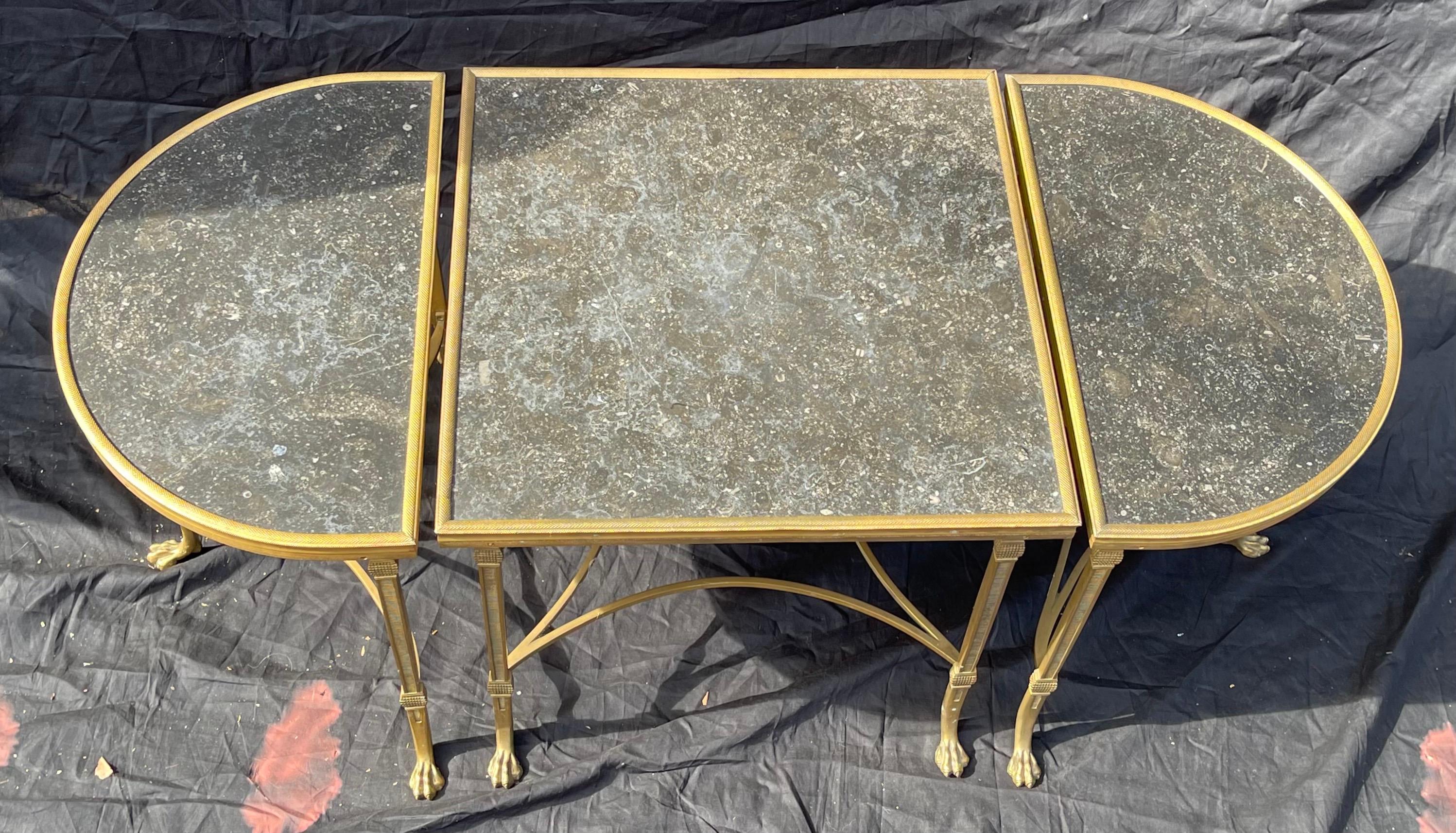 A wonderful French gilt bronze & black marble top three-part cocktail or coffee table with paw feet and stretchers across the bottom. Consisting of a square center sections and two rounded ends that are completely finished all the way around so that