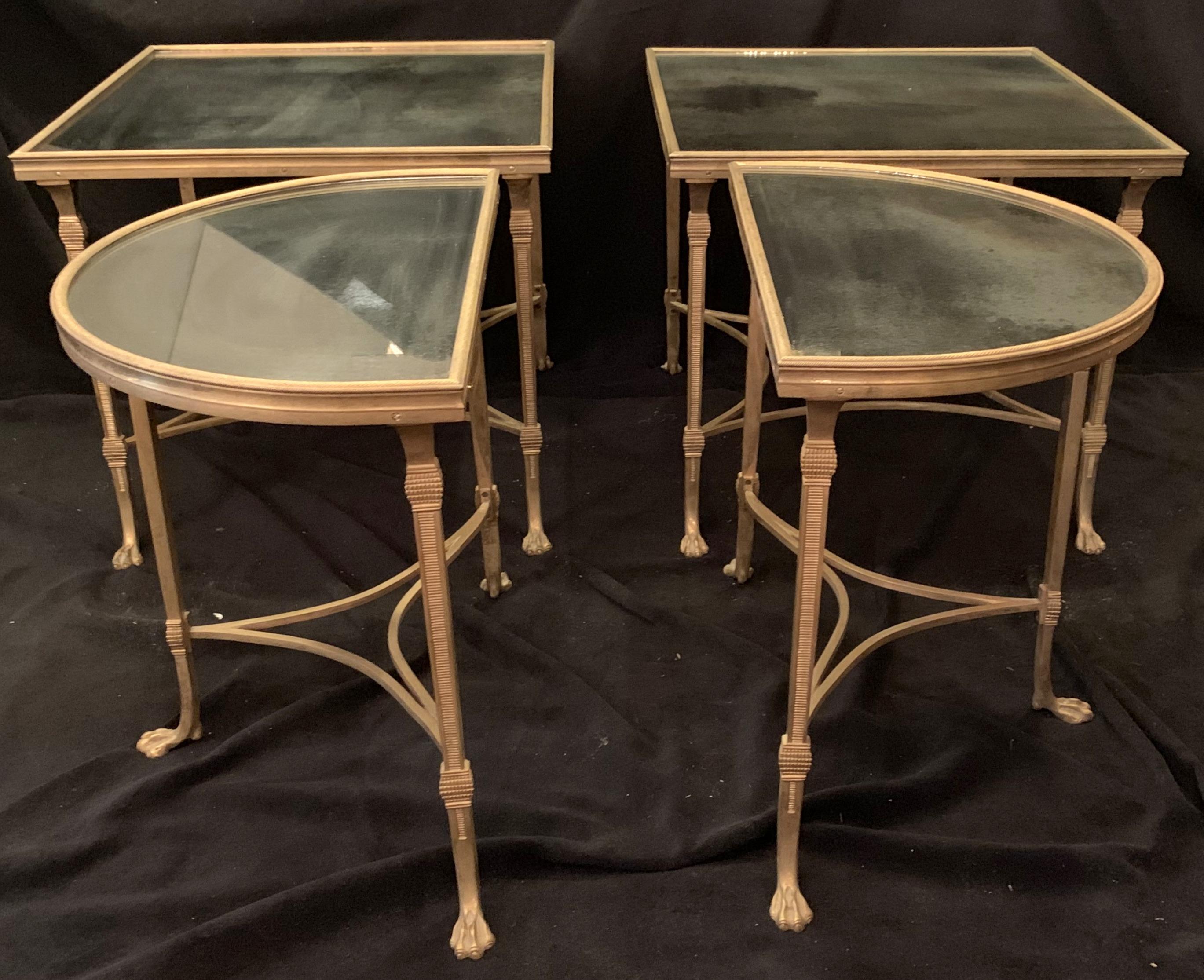 A wonderful French gilt bronze & antique mirrored four-part cocktail or coffee table with paw feet and stretchers across the bottom. Consisting of two square center sections and two rounded ends that are completely finished all the way around so