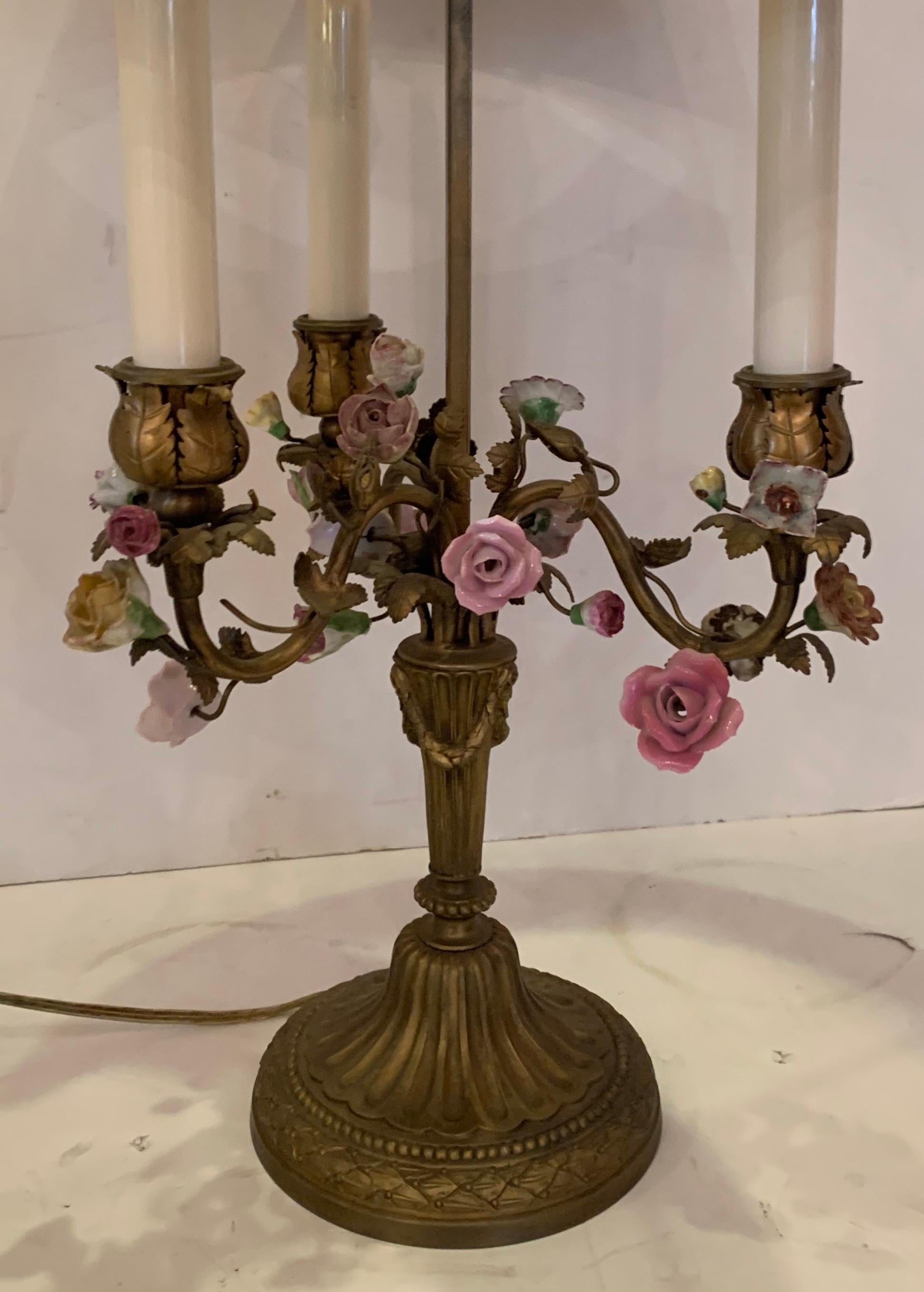 A wonderful French bronze candelabra Bouillotte lamp with porcelain flowers and red tole shade.