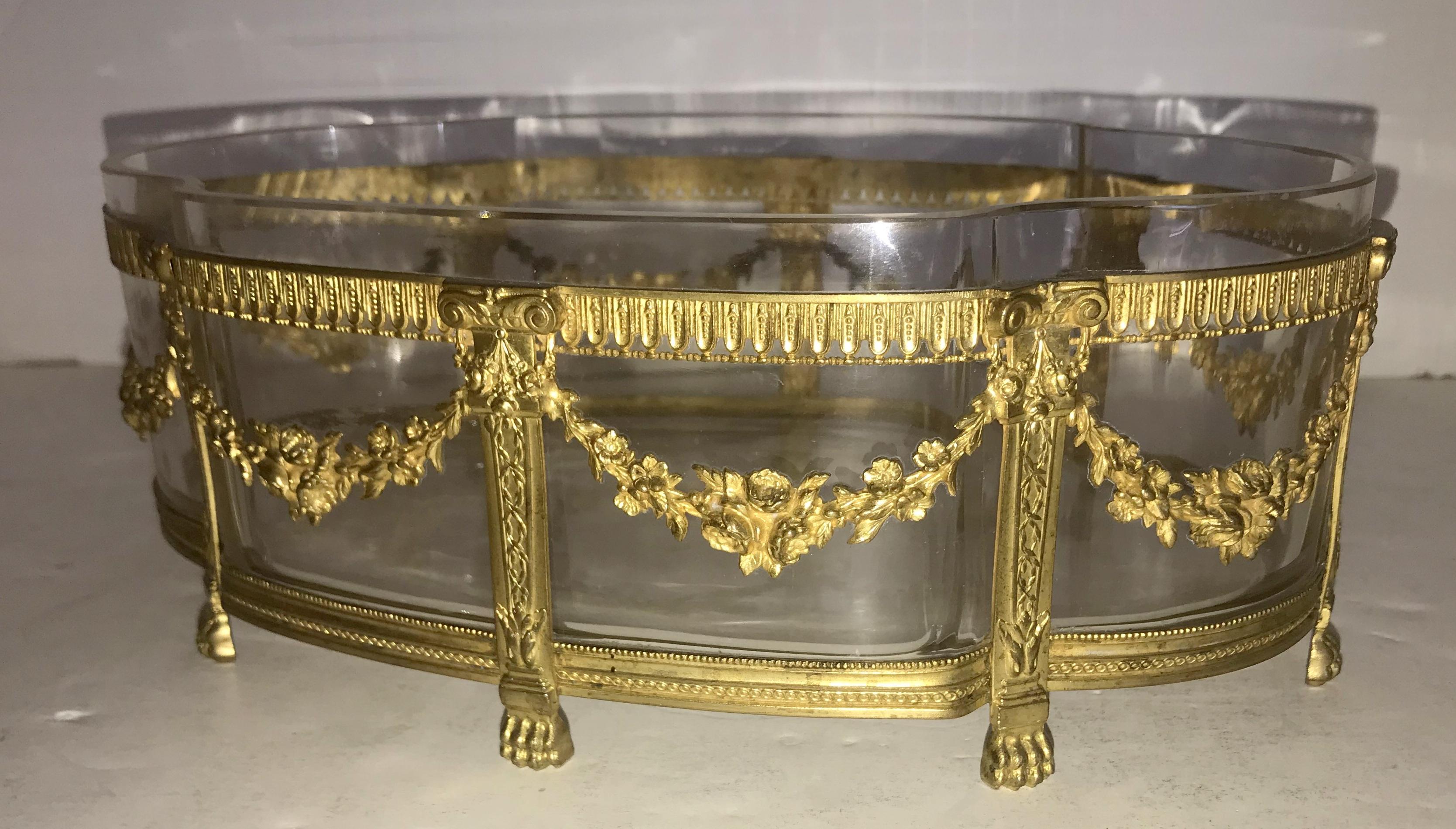 A wonderful French gilt bronze and crystal oval centerpiece decorated with wreaths and swags ormolu-mounted and raised on paw feet.