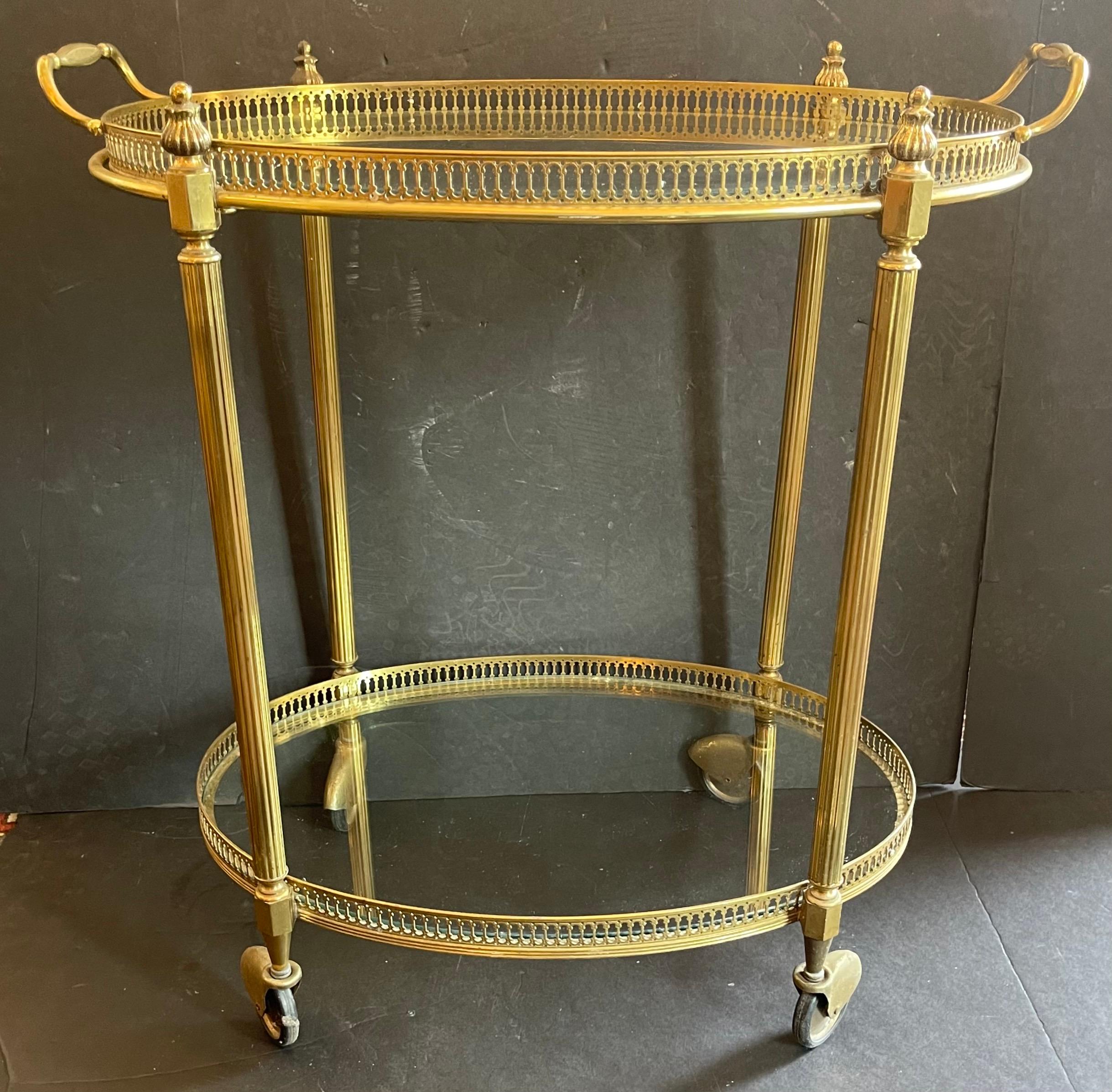 Ein wunderschöner französischer Barwagen im neoklassischen Stil mit 2 Etagen aus Bronze/Messing mit eingelassenen Glasböden und abnehmbarer Galerieplatte. Die Beschichtung ist insgesamt in gutem Zustand. Hochwertige Verarbeitung, darunter ein