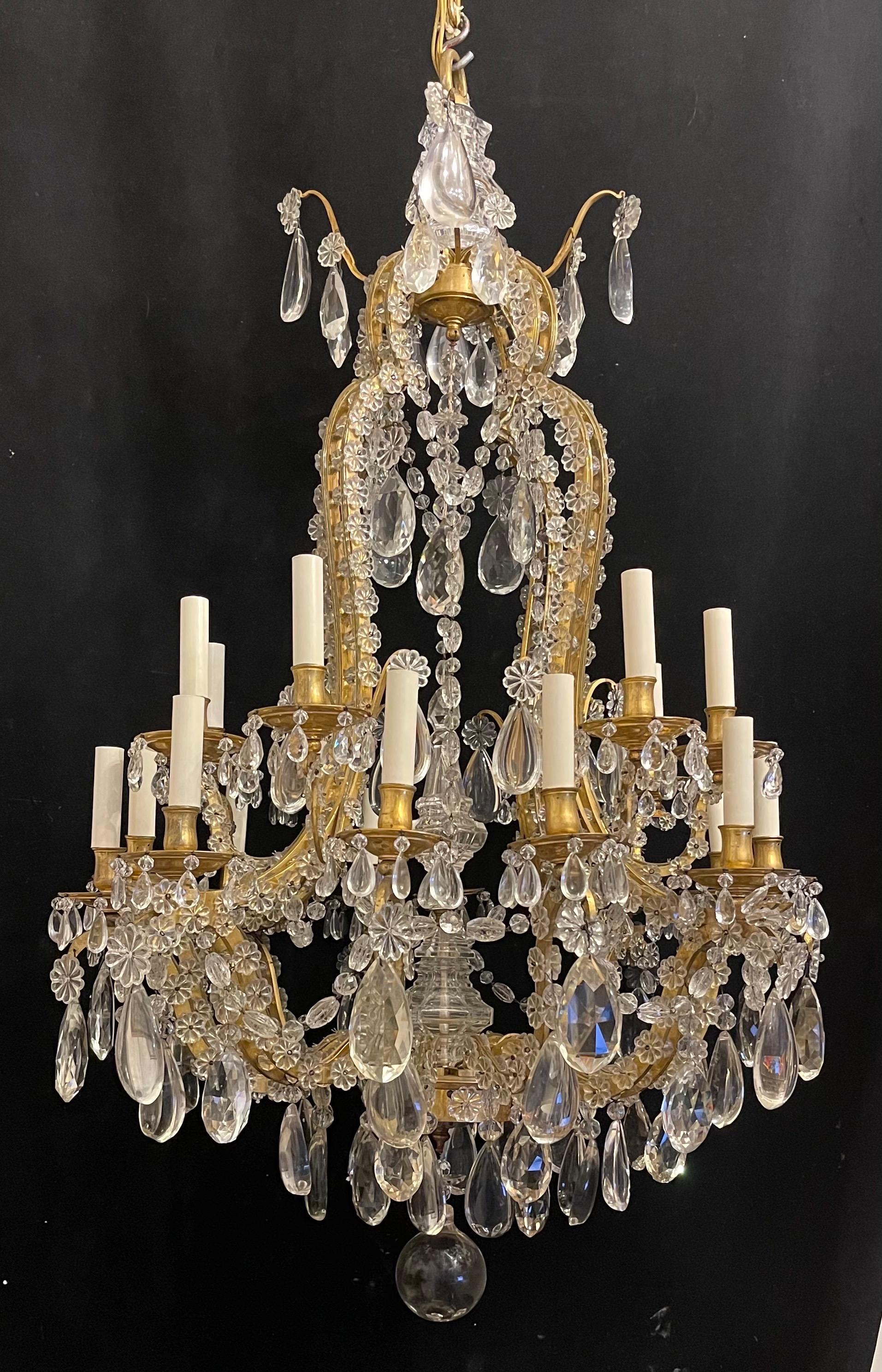 A wonderful French dore bronze & crystal with flower & beaded swag 20 light chandelier purchased from nestles NYC in the manner of Baguès.