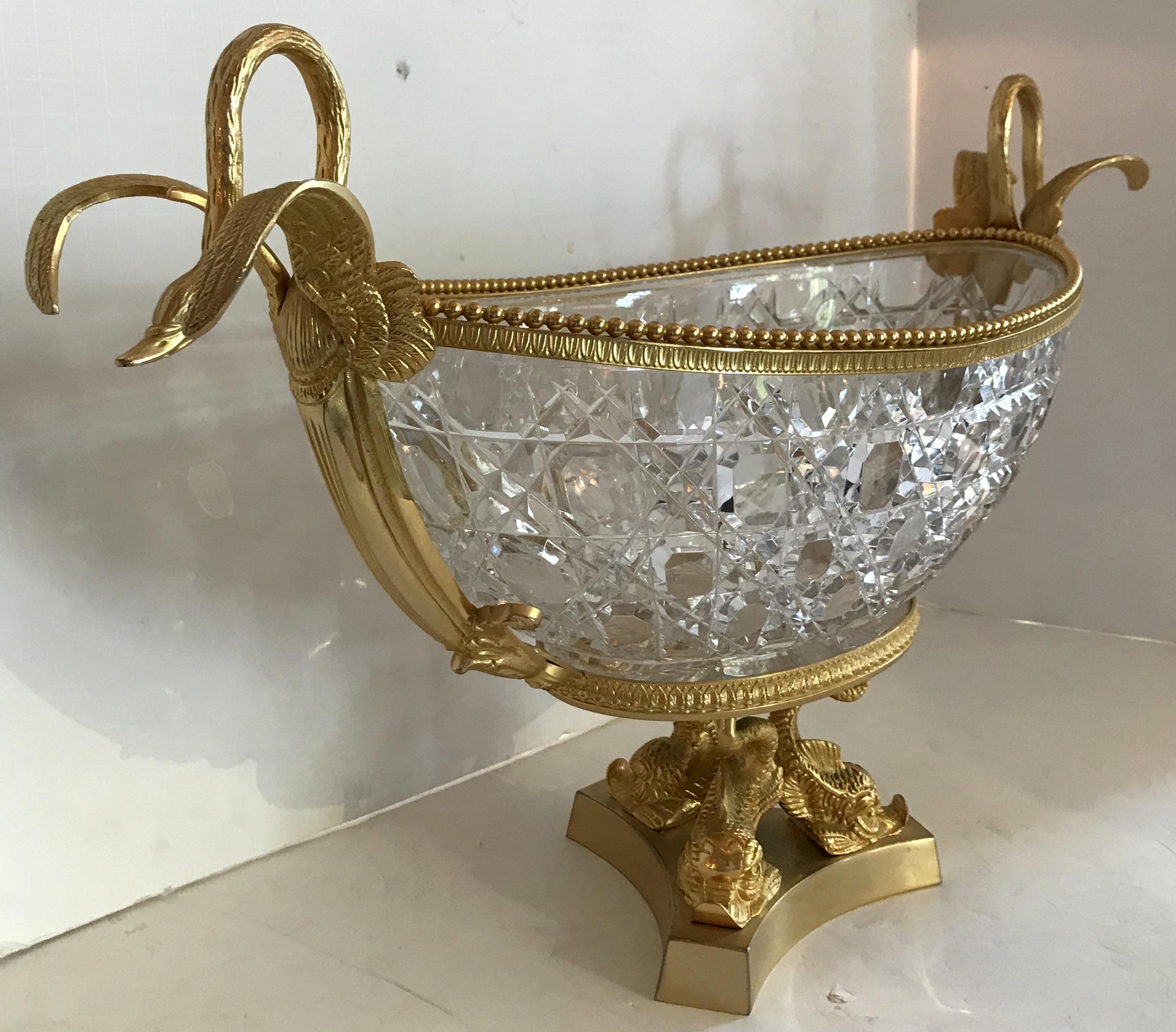 A wonderful large French doré´ bronze centerpiece with three dolphins on the pedestal and two lovely swans in flight on each side. The faceted fine cut crystal insert with star burst bottom add to the elegance of this impressive centerpiece. Etched