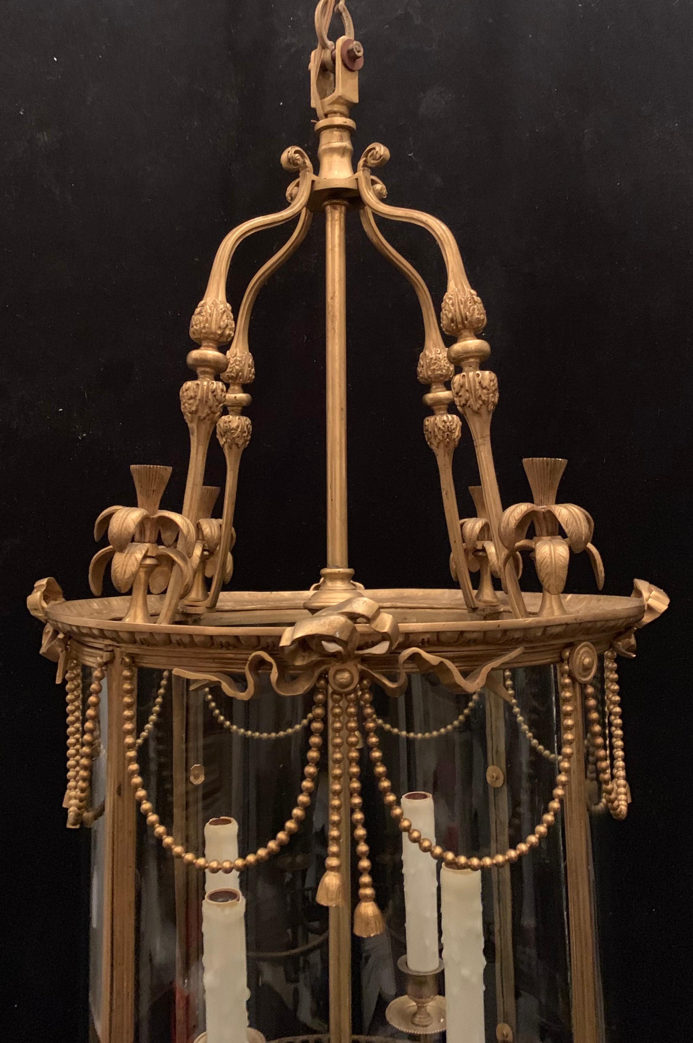 A Wonderful French doré bronze curved glass ormolu-mounted with bows and swags and tassels Lantern 4 candelabra light fixture
Provenance: Sotheby's Auction House New York City
Wiring has been updated, accompanied by chain and canopy as well as