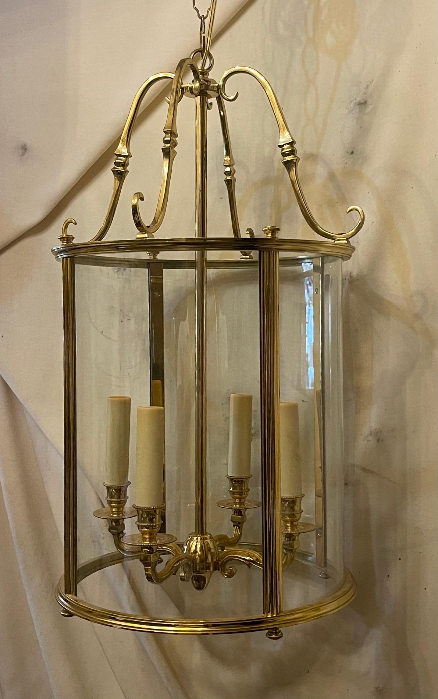 Eine elegante vierflammige Laterne aus Doré-Bronze mit geätzter, gerippter Bronzeverzierung und eingesetzter, gebogener Glasscheibe. Die Leuchte hat vier Kandelaber mit schönen, geschwungenen Details, die zur oberen Krone führen.
