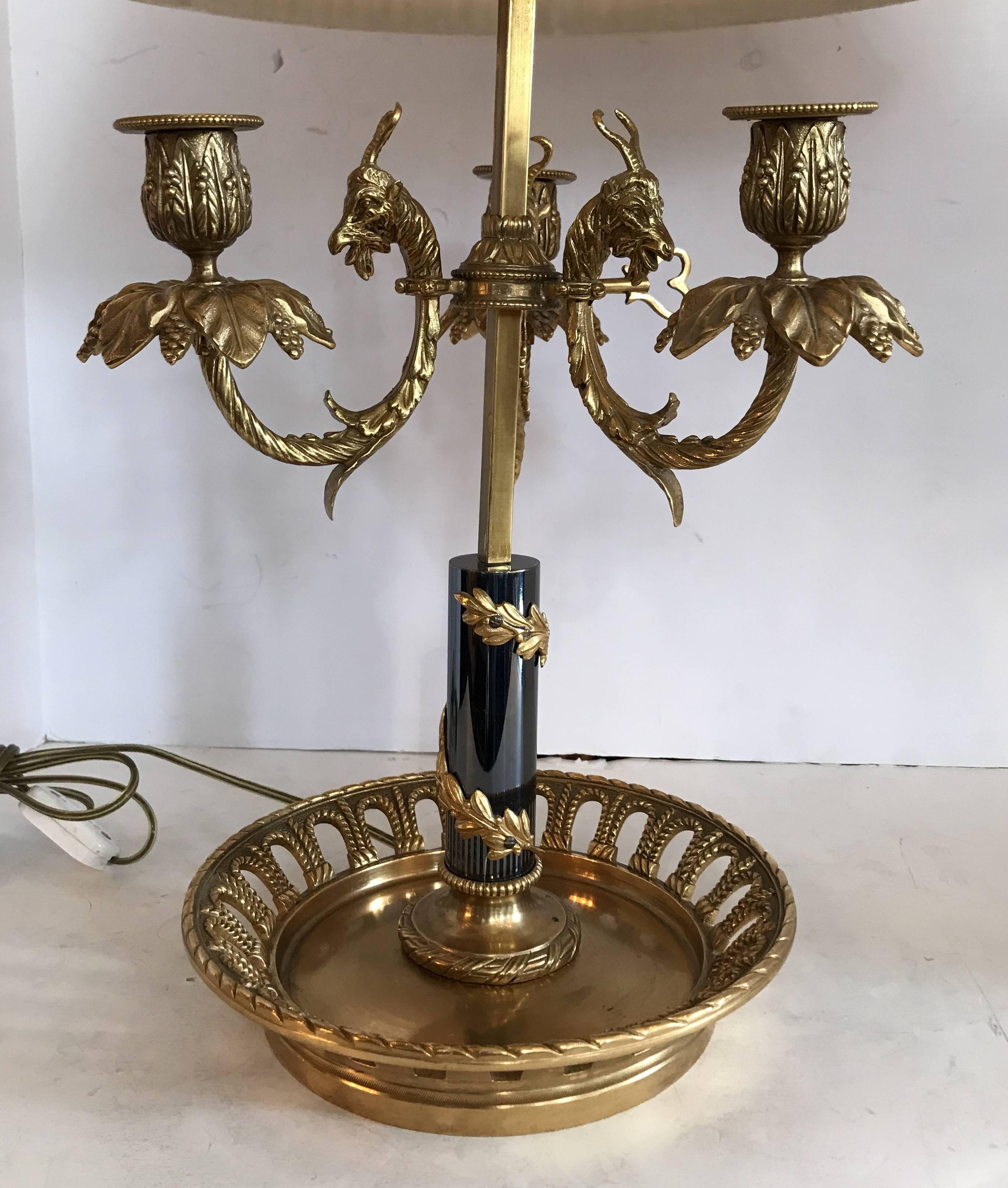 A wonderful large and rare French empire bronze Bouillet table lamp with goat heads in the manner of Pierre Gouthiere with basket form base and silk shade. Rewired with three candelabra sockets, shade does have minor indentations in the silk from