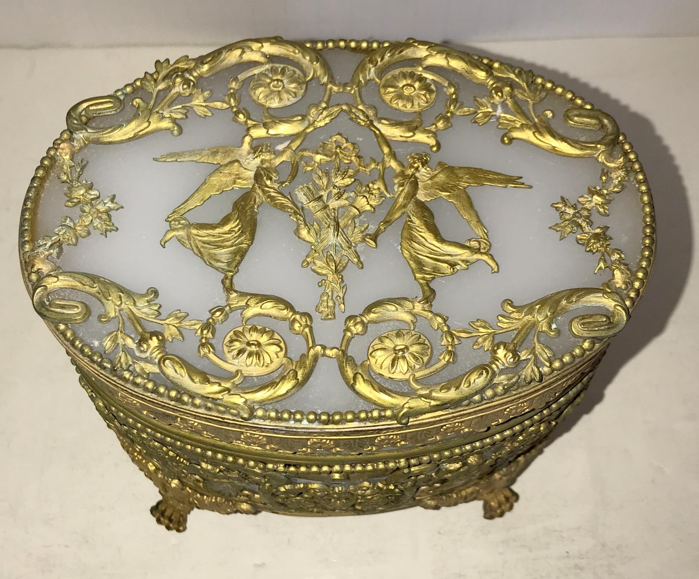 A very fine and wonderful French empire gilt doré bronze and white opaline neoclassical oval ormolu casket with raised paw feet Regency box.