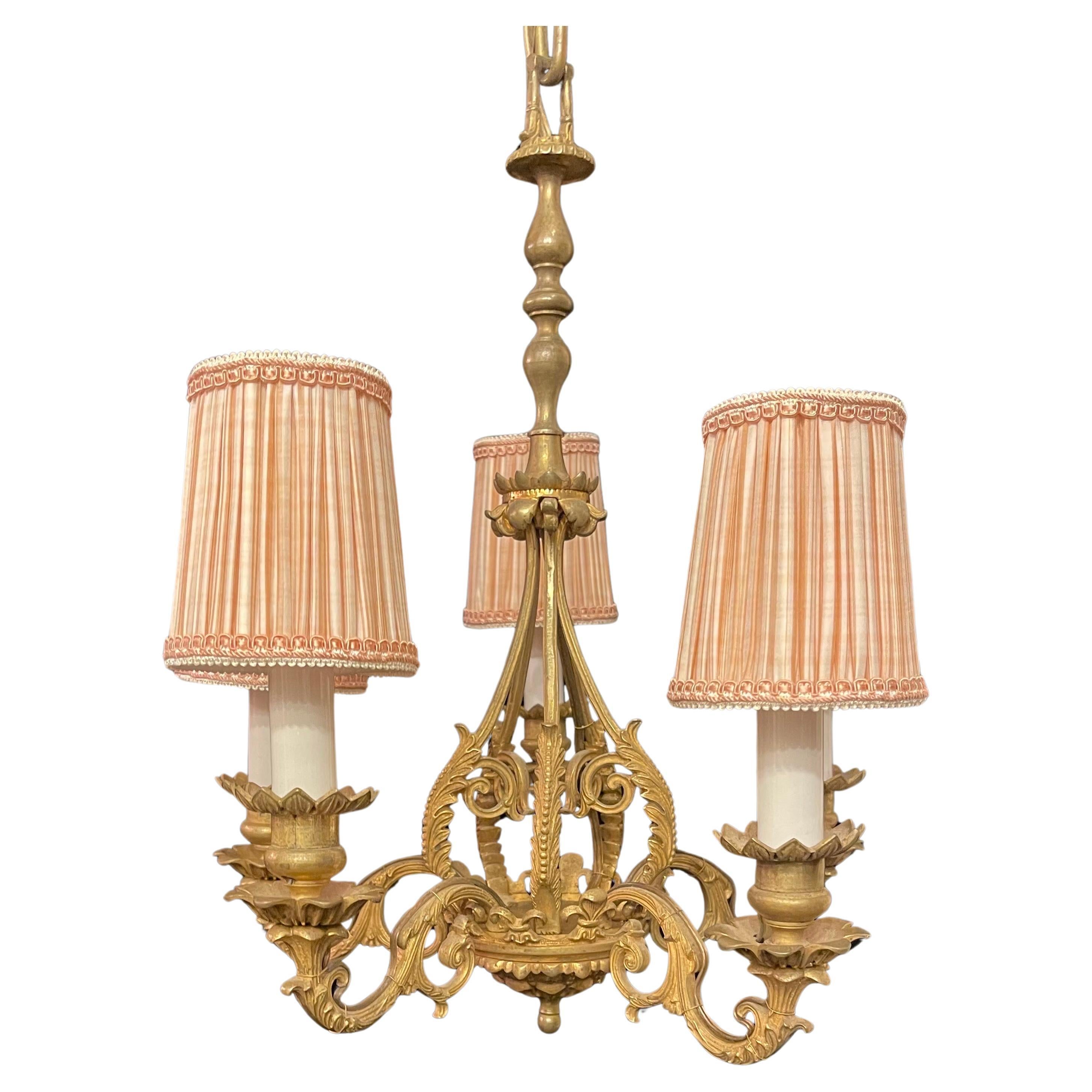 Merveilleux lustre Empire français en bronze doré de style Régence à cinq candélabres. Ce luminaire est livré avec des abat-jours qui peuvent être enlevés. 