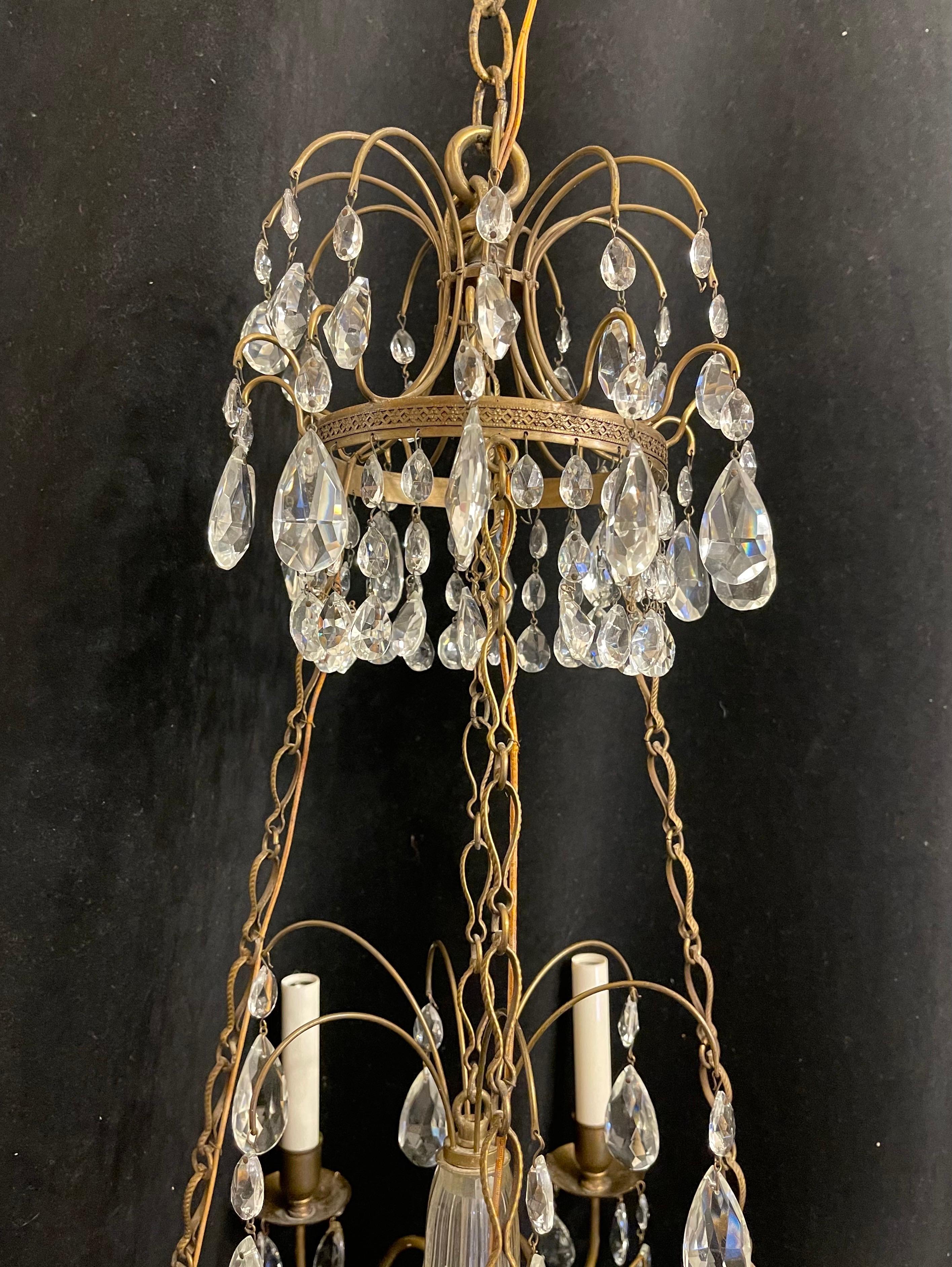 Un meraviglioso lampadario francese Impero / neoclassico / Regency in bronzo e cristallo graduato a forma di cesto con teste di medusa e sei prese a candelabro intorno alla cornice esterna e un bellissimo medaglione centrale a spruzzo e rifinito con