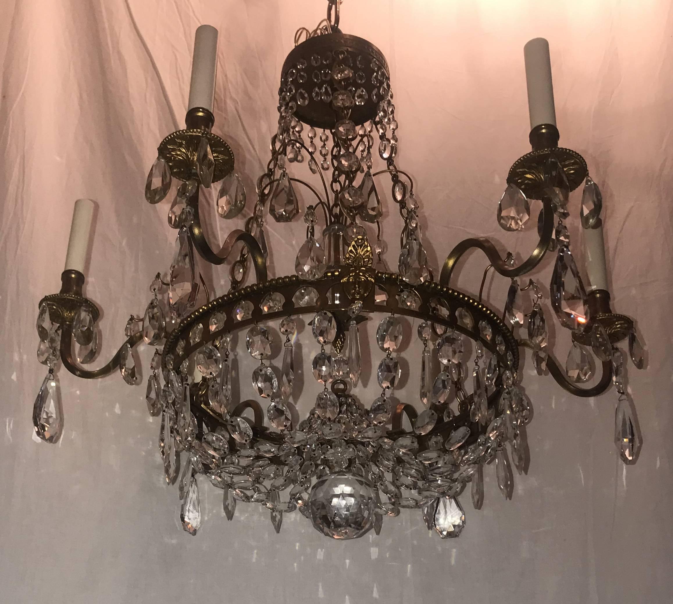 A wonderful French Empire / neoclassical / Regency bronze and graduating crystal basket form chandelier with medusa heads and six candelabra sockets around the outer frame and a beautiful centre spray medallion and finished with a centre ball.