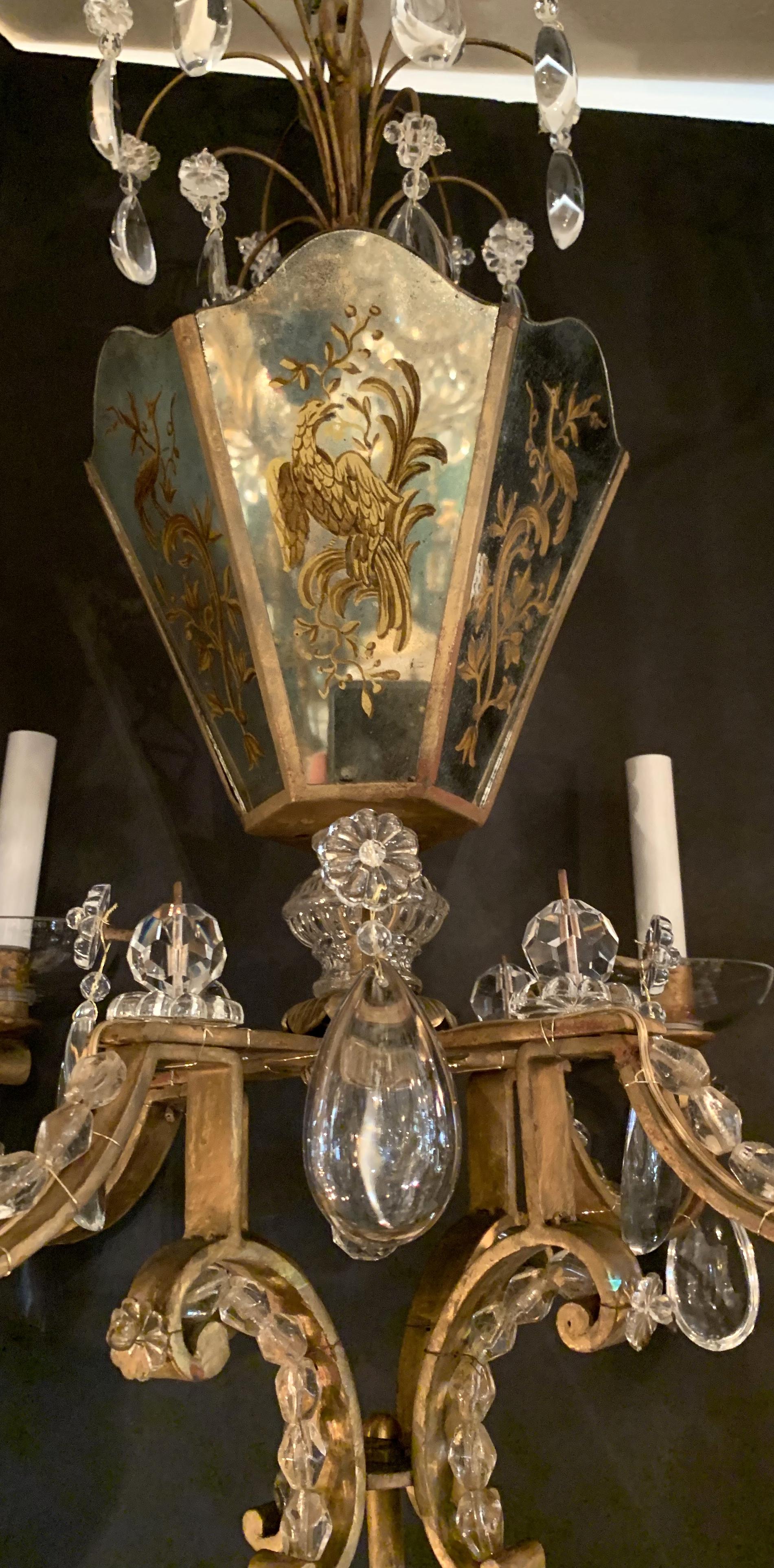 A wonderful French gold gilt chandelier in the manner of Baguès, from the iconic 1920s period. This stunning piece has 6 reverse painted mirrored panels forming a basket as the centerpiece and contains 3 candelabra lights within. From the centre