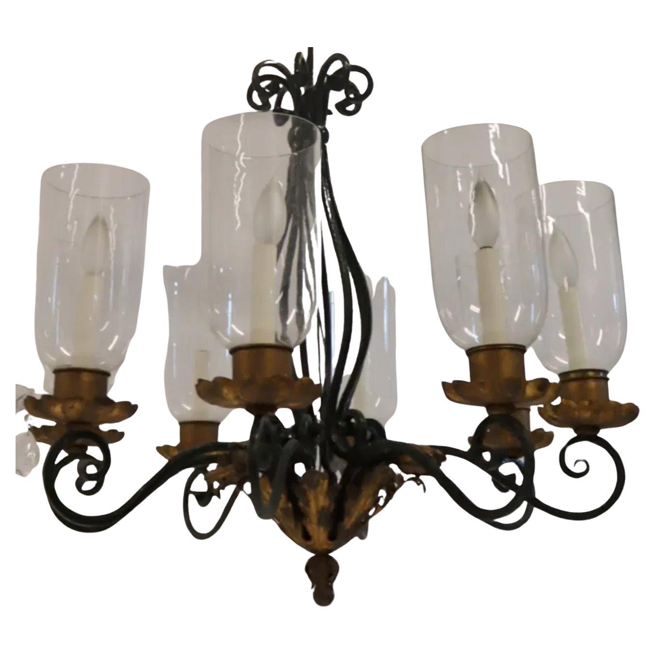 Meraviglioso lampadario francese in ferro dipinto di verde con riflessi dorati, con 8 candelabri di vetro a forma di uragano