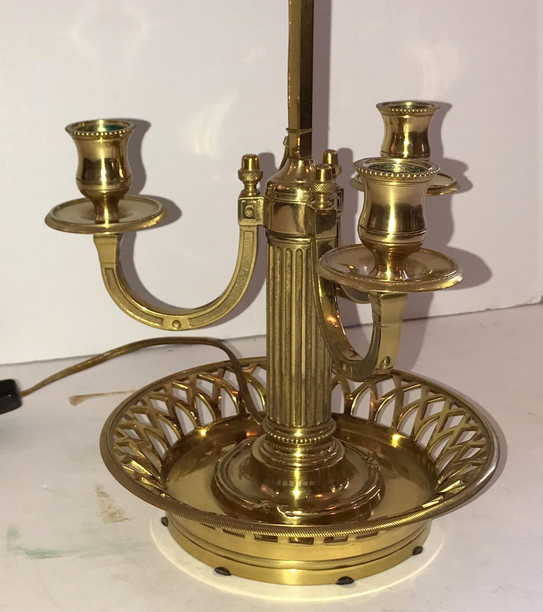 Merveilleuse lampe de table bouillotte à trois bras, de style Louis XVI, en bronze, avec abat-jour réglable en métal noir à poignée en plume et épi de faîtage en forme de gland, colonne centrale cannelée et base ajourée en forme de panier.