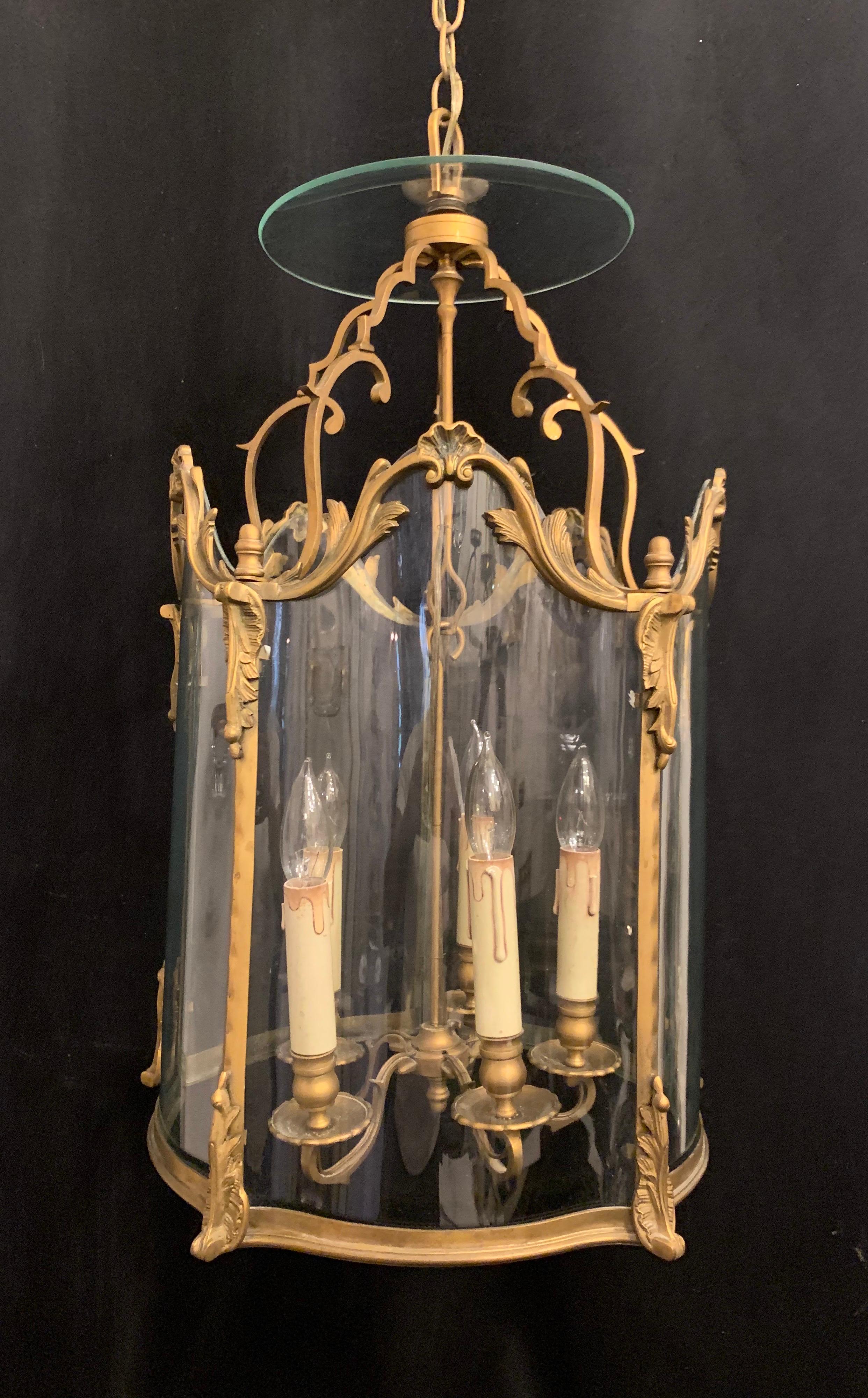 A wonderful French Louis XVI gilt bronze and curved panel glass lantern fixture with 5 candelabra sockets, rewired and ready to install with chain canopy and mounting hardware.
