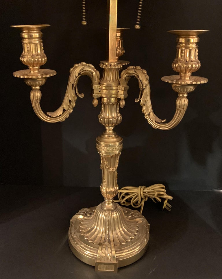 A wonderful large French neoclassical Louis XVI gilt bronze bouillotte lamp with three acanthus leaf arms and fluted center shaft with applied swags and top offed with a swan head green painted tole shade.