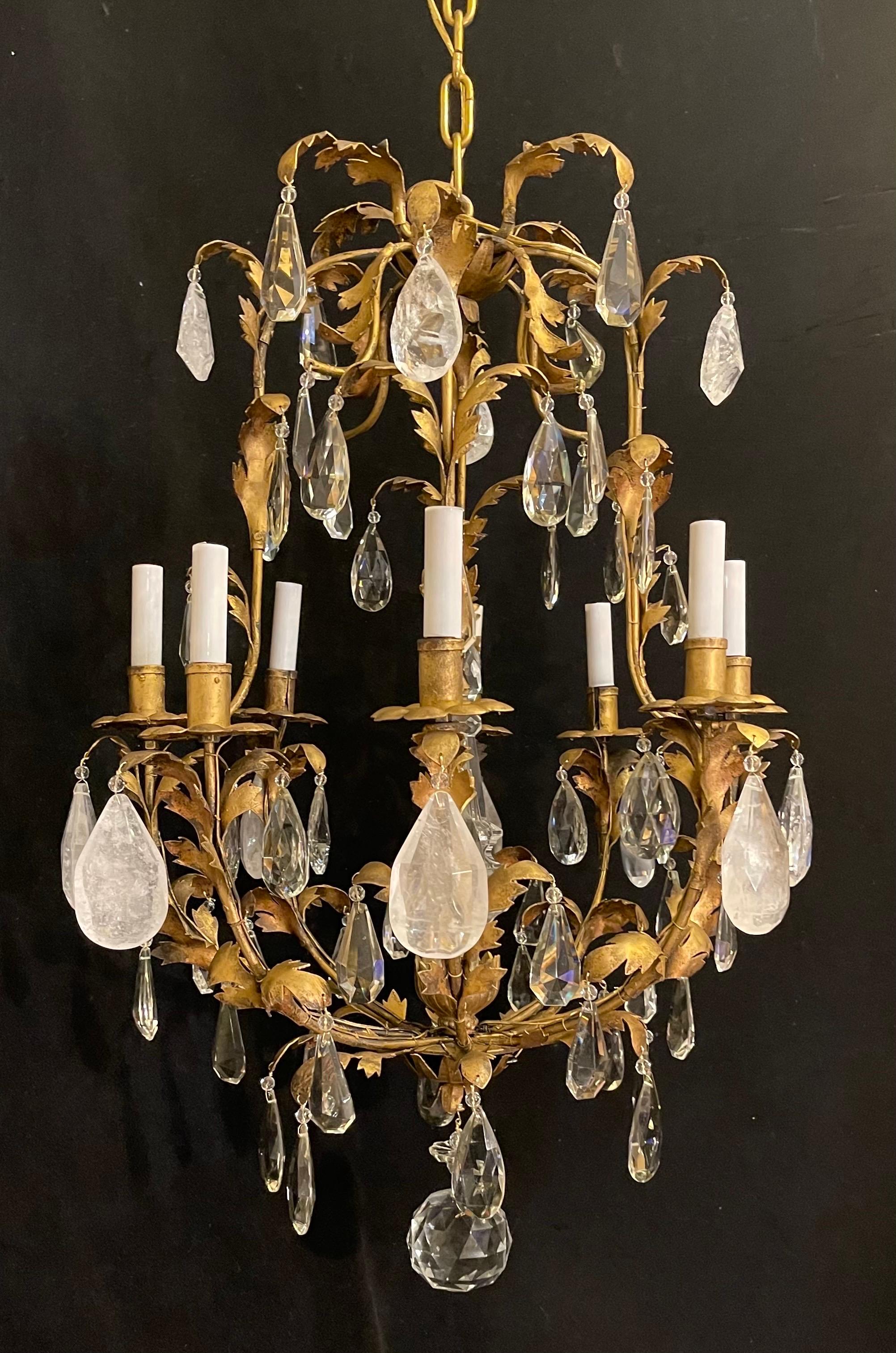 Meraviglioso lampadario a forma di gabbia per uccelli in stile Maison Baguès in oro dorato, ornato da un'alternanza di cristalli e cristalli di rocca, con al centro un obelisco in vetro artistico.
Il cablaggio è stato aggiornato ed è pronto per