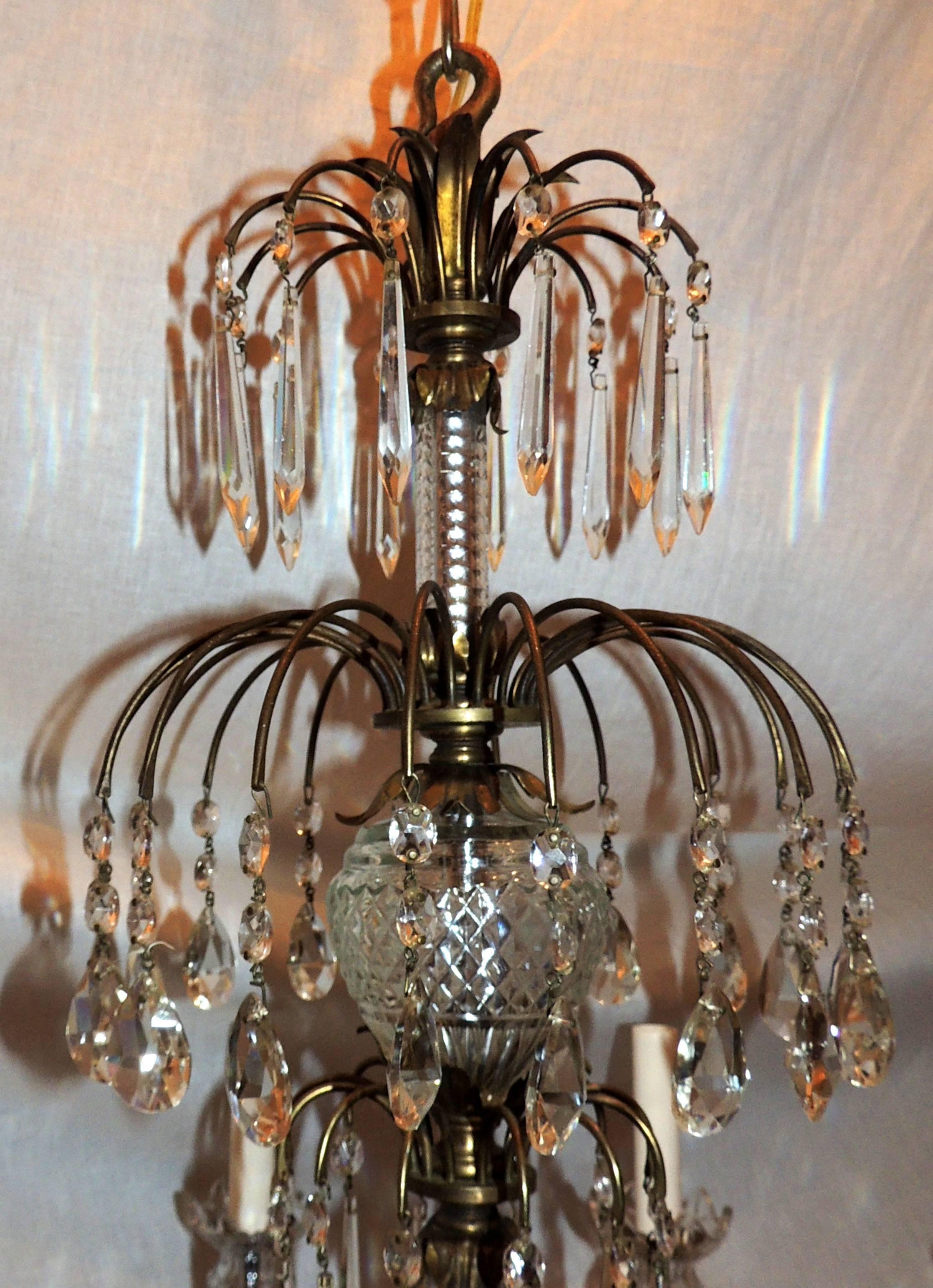 A wonderful French neoclassical bronze and crystal chandelier in the Regency, Baltic design. Each of the eight arms are draped with delicate crystals, and fished with an elegant cut crystal bobéches that sits on a waterfall bronze cascade with