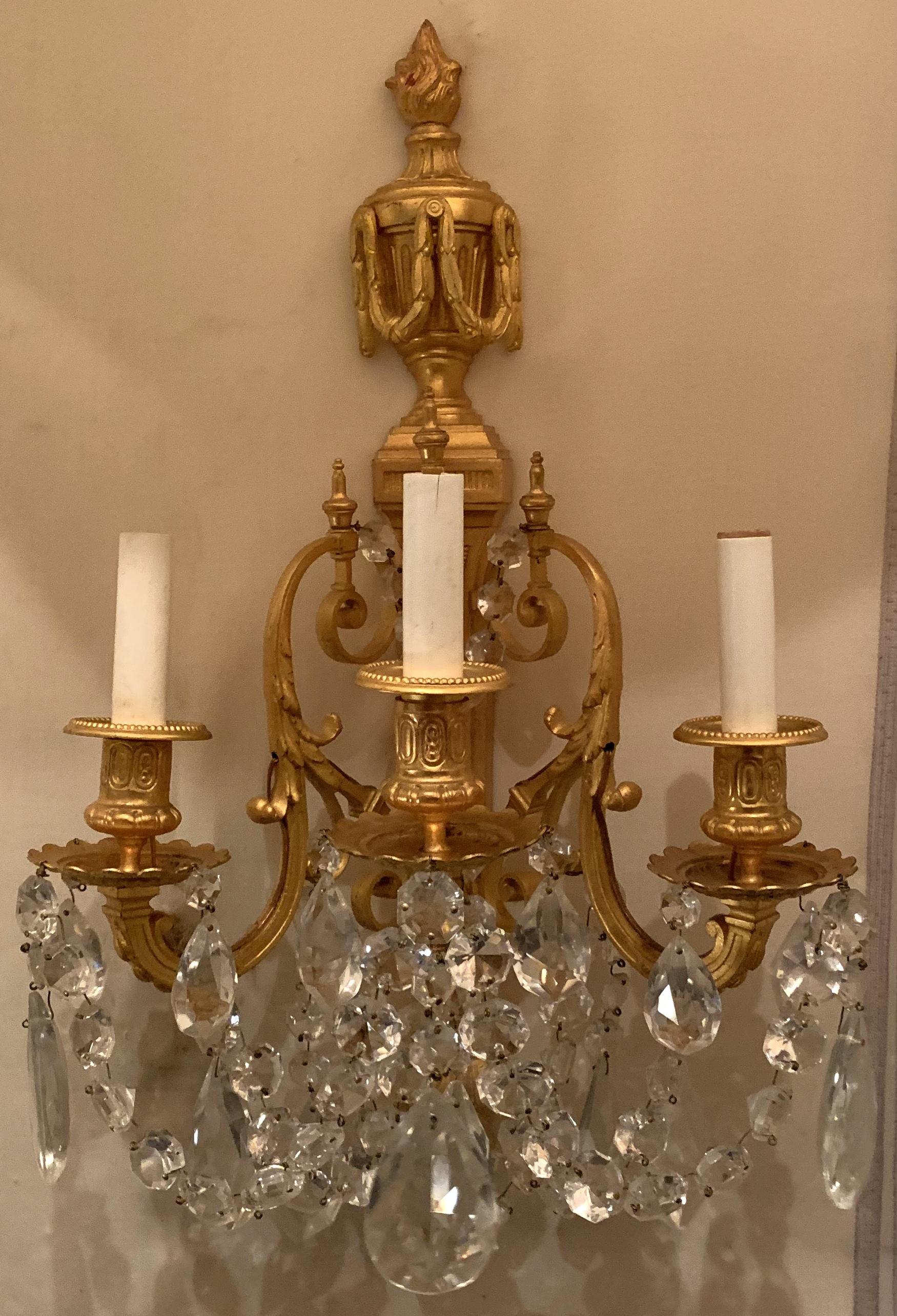 A wonderful French neoclassical pair of doré bronze and crystal swag urn and flame top sconces with 3 candelabra lights.
