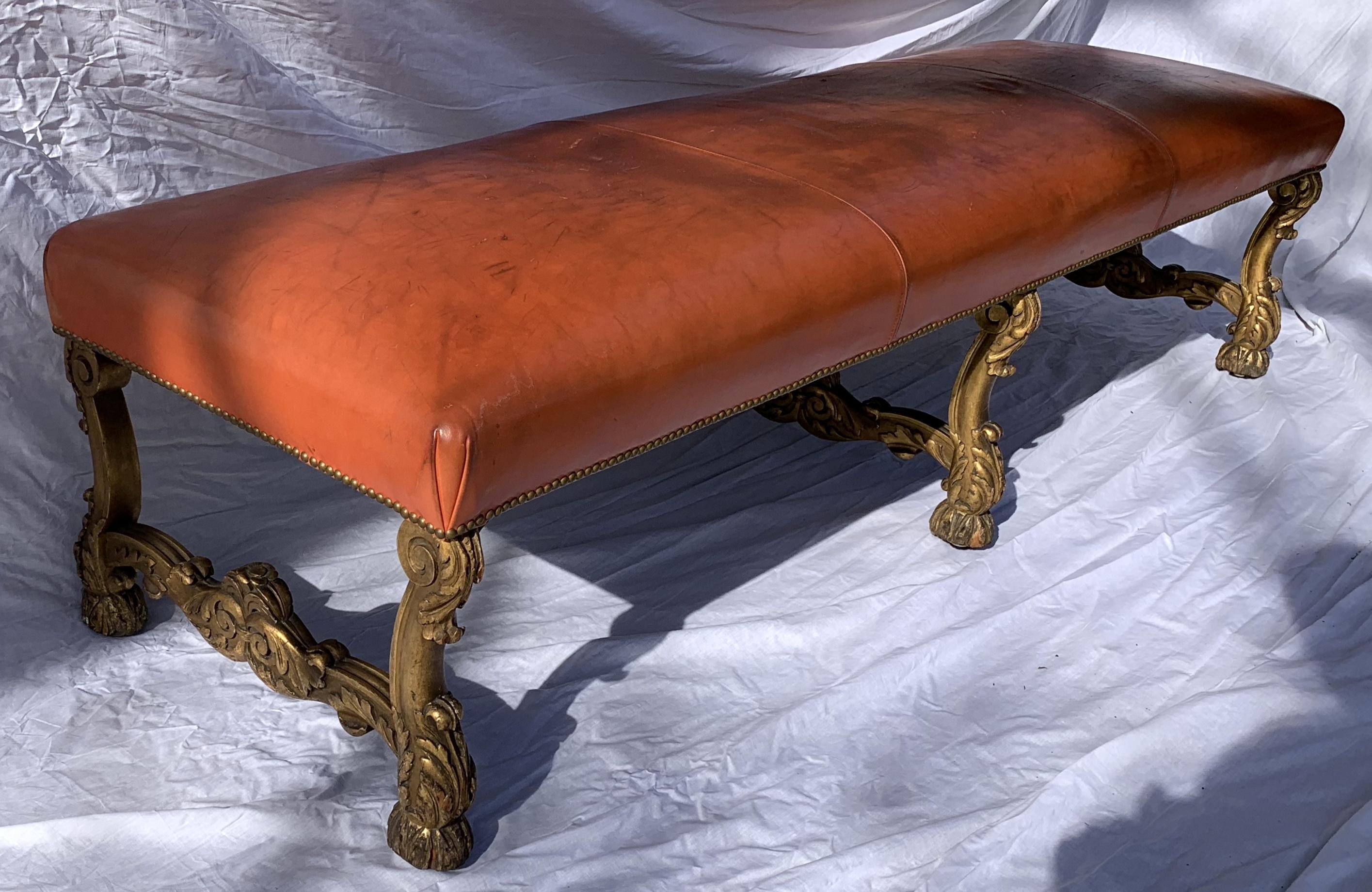 A wonderful French 19th century large regency rectangular carved giltwood nail head orange fine leather bench.
Minor wear to patina on legs and leather top.
 