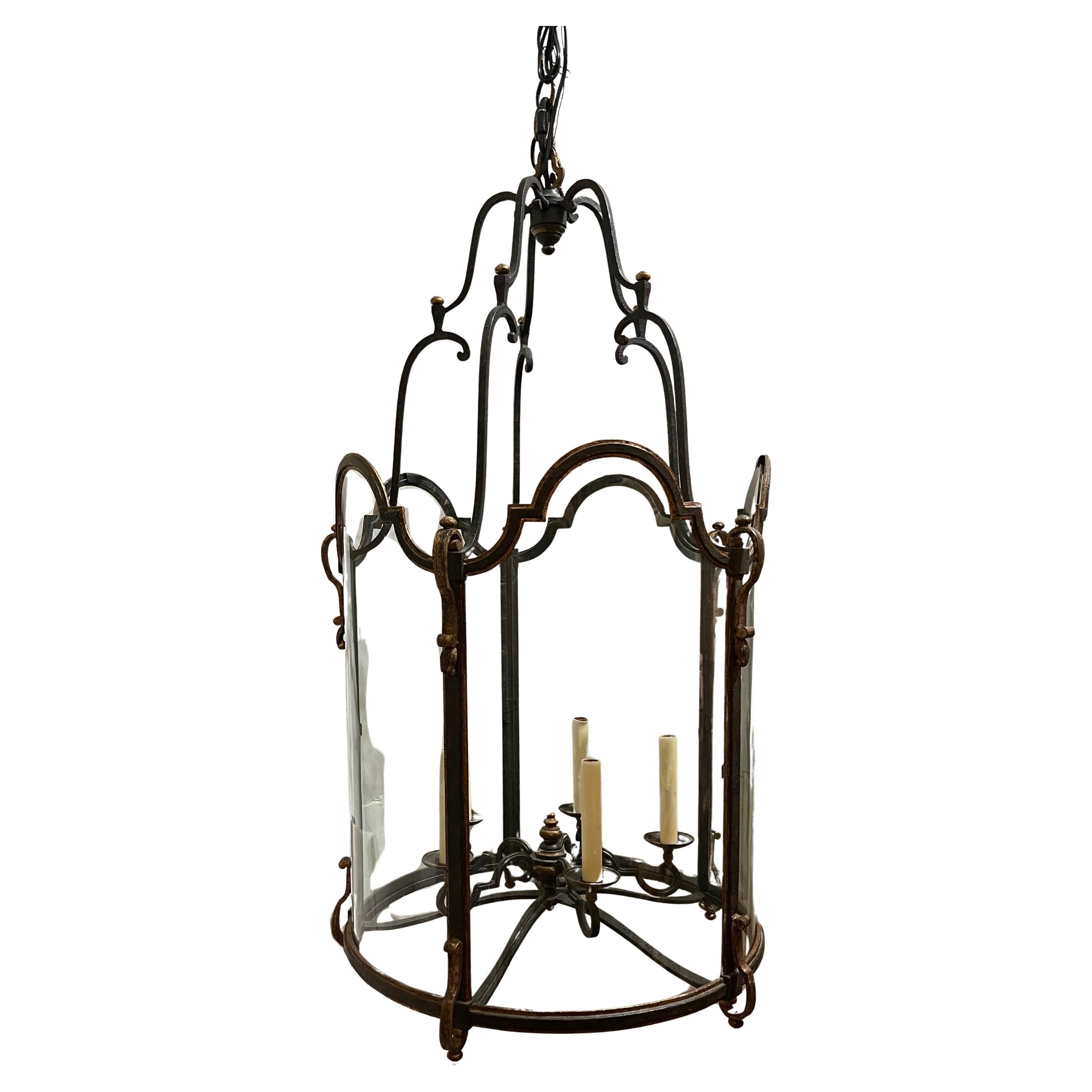 Merveilleux lustre lanterne en fer forgé de style Régence avec garniture dorée, avec 5 chandeliers intérieurs.
Accompagné d'une chaîne et d'un dais