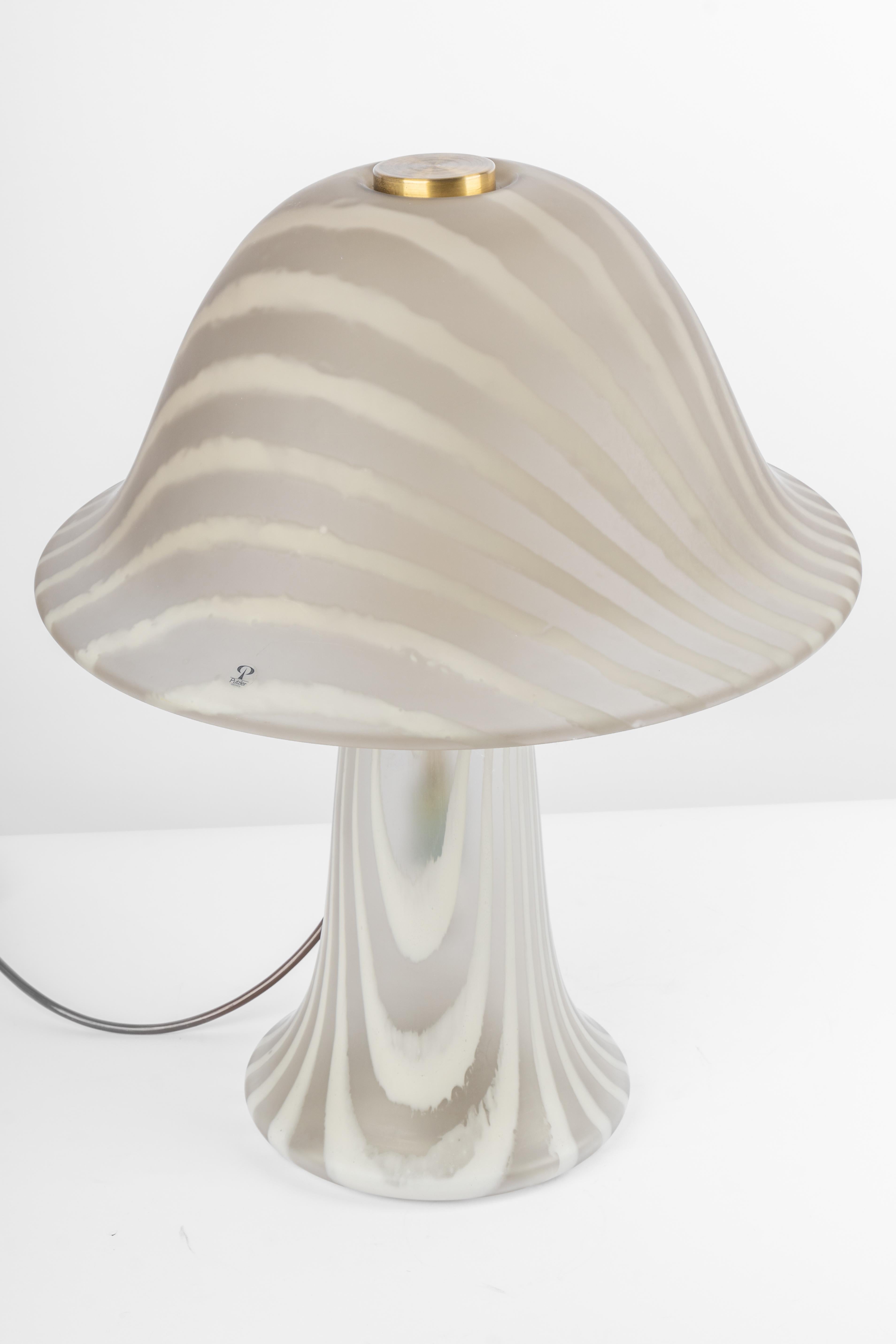 Merveilleuse lampe de table en forme de champignon de Peill & Putzler, Allemagne, années 1970. Fabriqué en 2 pièces.
Le corps en verre et sa qualité tranchante contrastent joliment avec la surface lisse et la forme du champignon. 

Mesures : Grande