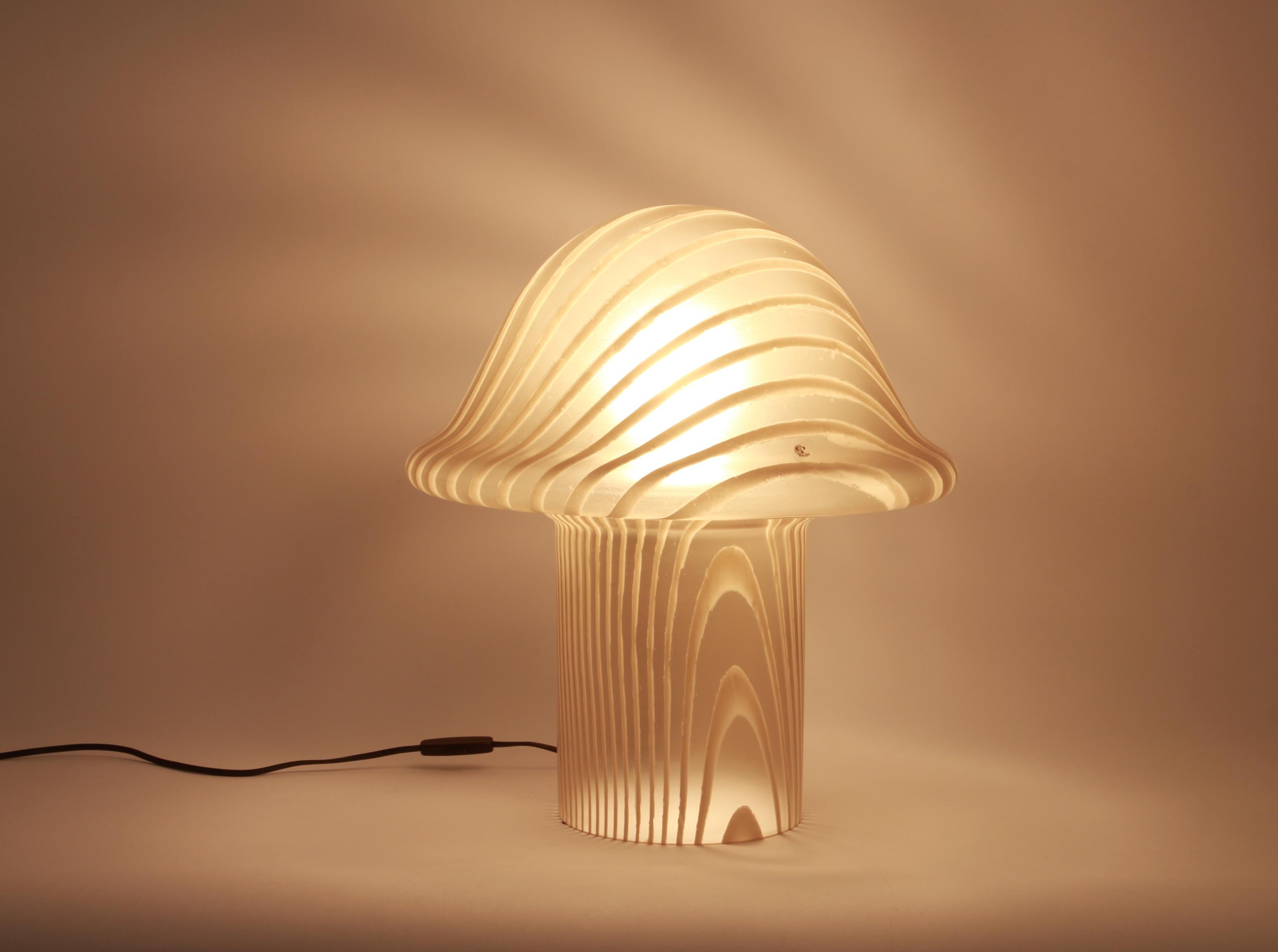 Merveilleuse lampe de table champignon de Peill & Putzler, Allemagne, années 1970. Fabriqué en une seule pièce.
Le corps en verre et sa qualité tranchante contrastent joliment avec la surface lisse et la forme du champignon. 

Mesures : Grande lampe