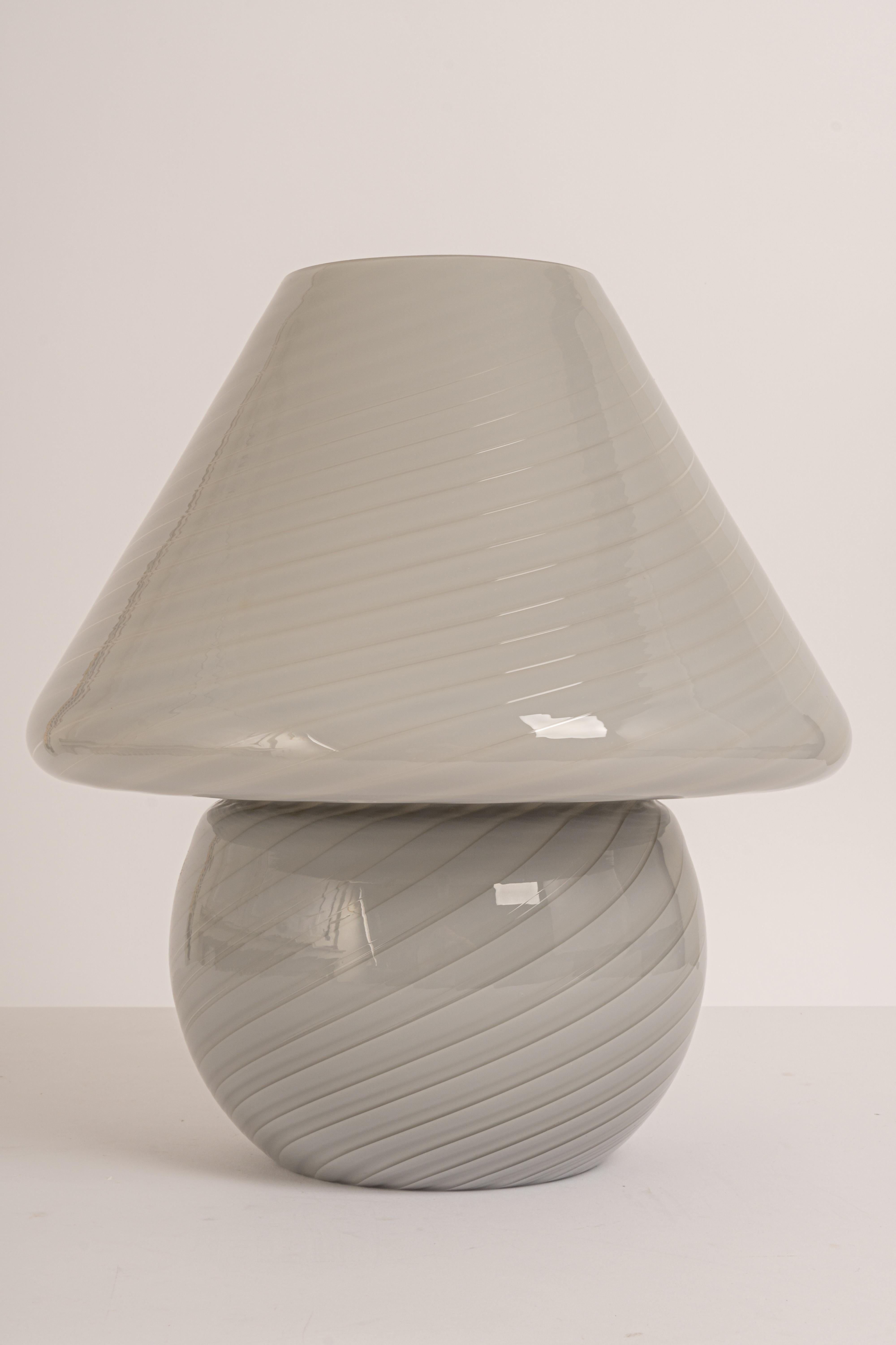 Wonderful mushroom table lamp by Peill & Putzler, Germany, 1970s. Made of a single piece.
Great glass body and its edgy quality contrast nicely with the smooth surface and shape of the mushroom. 

Measures: Large table lamp
Height 37 cm // 14.6