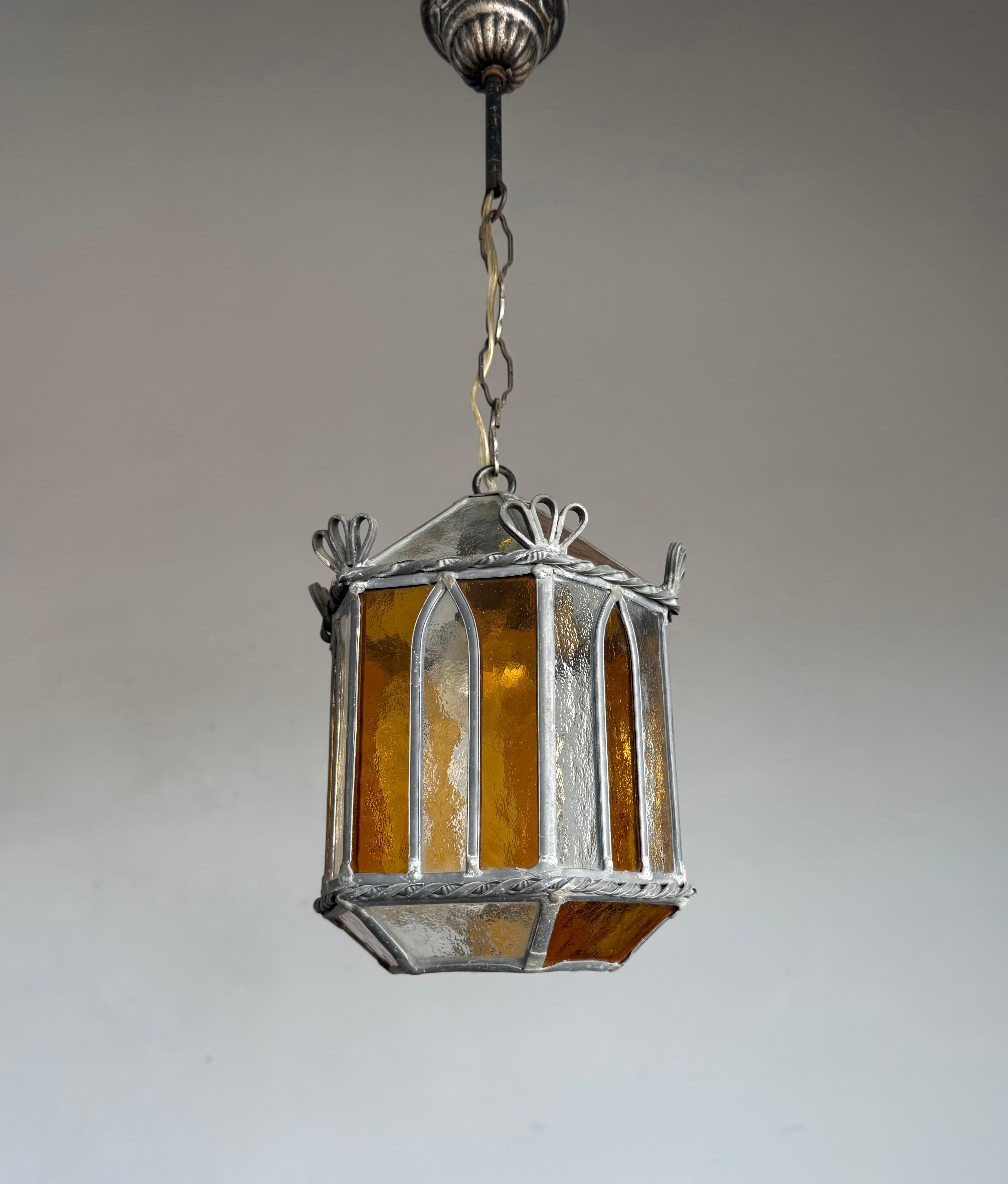 This rare and beautiful ceiling lamp is a true gem for anyone looking to create the perfect ambiance.

Crafted in the 1920s, this unique Gothic Revival pendant showcases a geometric design with stylized church window motifs, executed in richly