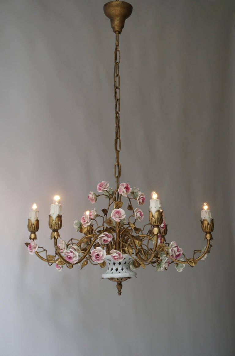 Mid century Italian brass and Porcelain Flowers chandelier 

Charming gilt brass chandelier with six candle branches and a central porcelain vase/basket placed in the center of the chandelier frame.The branches adorned with brass leaves.The