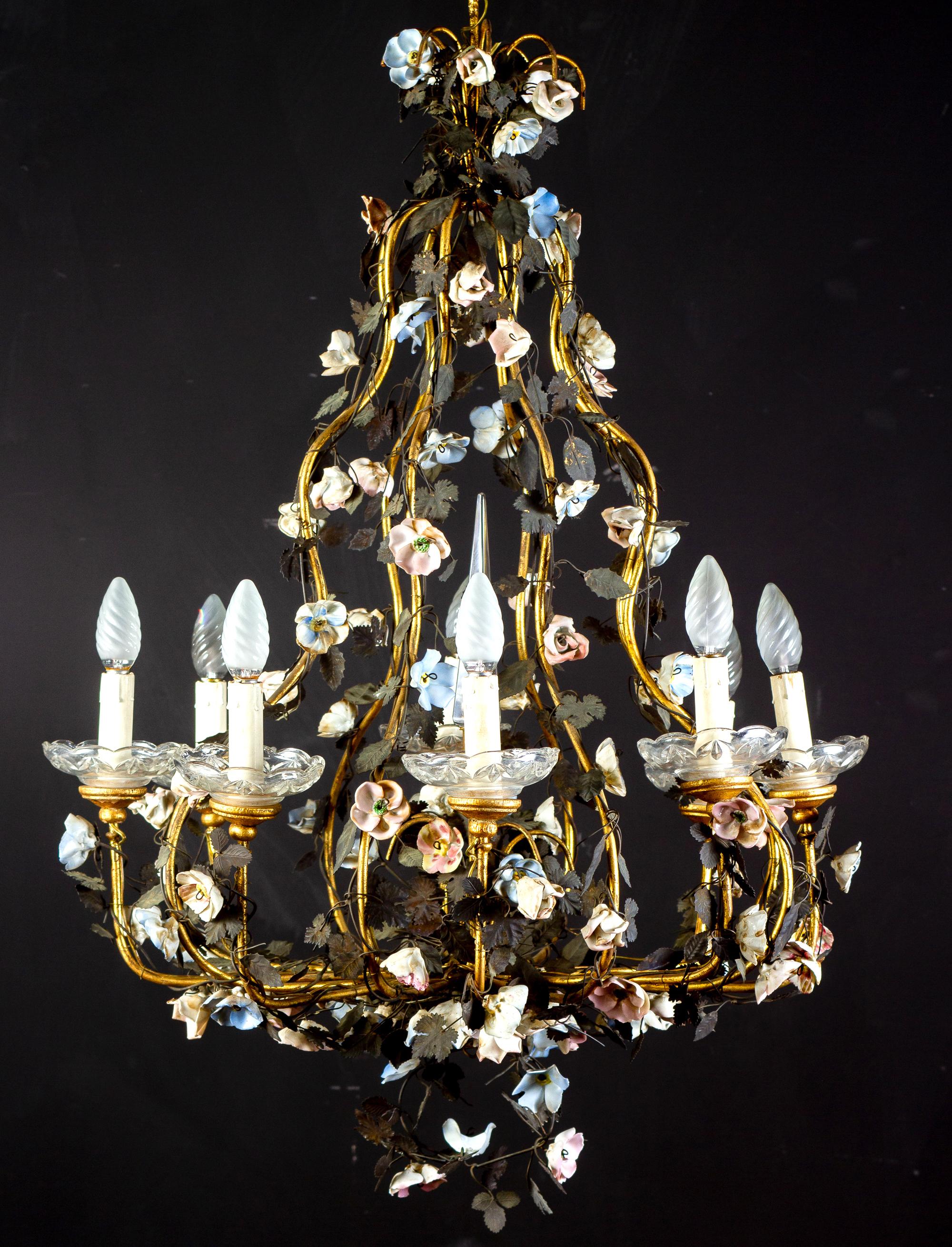 19th century Italian Piedmontese cage form chandelier ornamented with colorful porcelain flowers and hand painted tole leaves.
Eight arms with delicious crystal candle holders.
Eight E14 light bulbs, we can rewire for your country