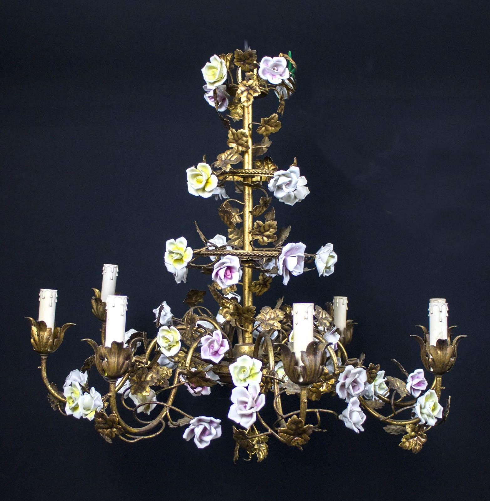 19th century Italian Piedmontese cage form chandelier ornamented with colorful porcelain flowers and hand painted tole leaves.
Six arms with six candle holders.
Hight cm 75 plus chain and canopy 120cm Diameter 80 cm 
Six E14 light bulbs, we can