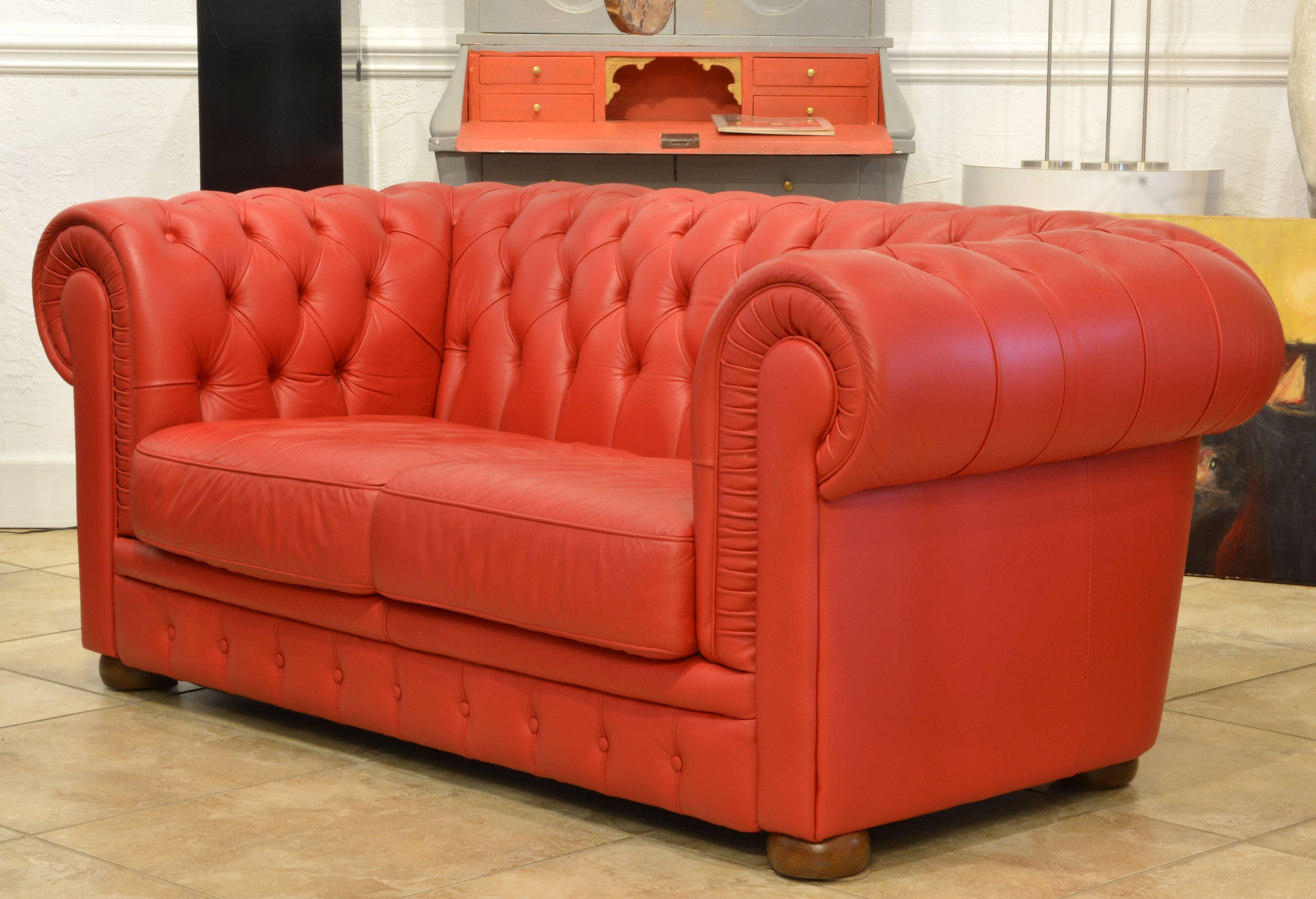 Covered with glove quality red leather and featuring excellent craftsmanship this modern Chesterfield sofa makes a very attractive impression.