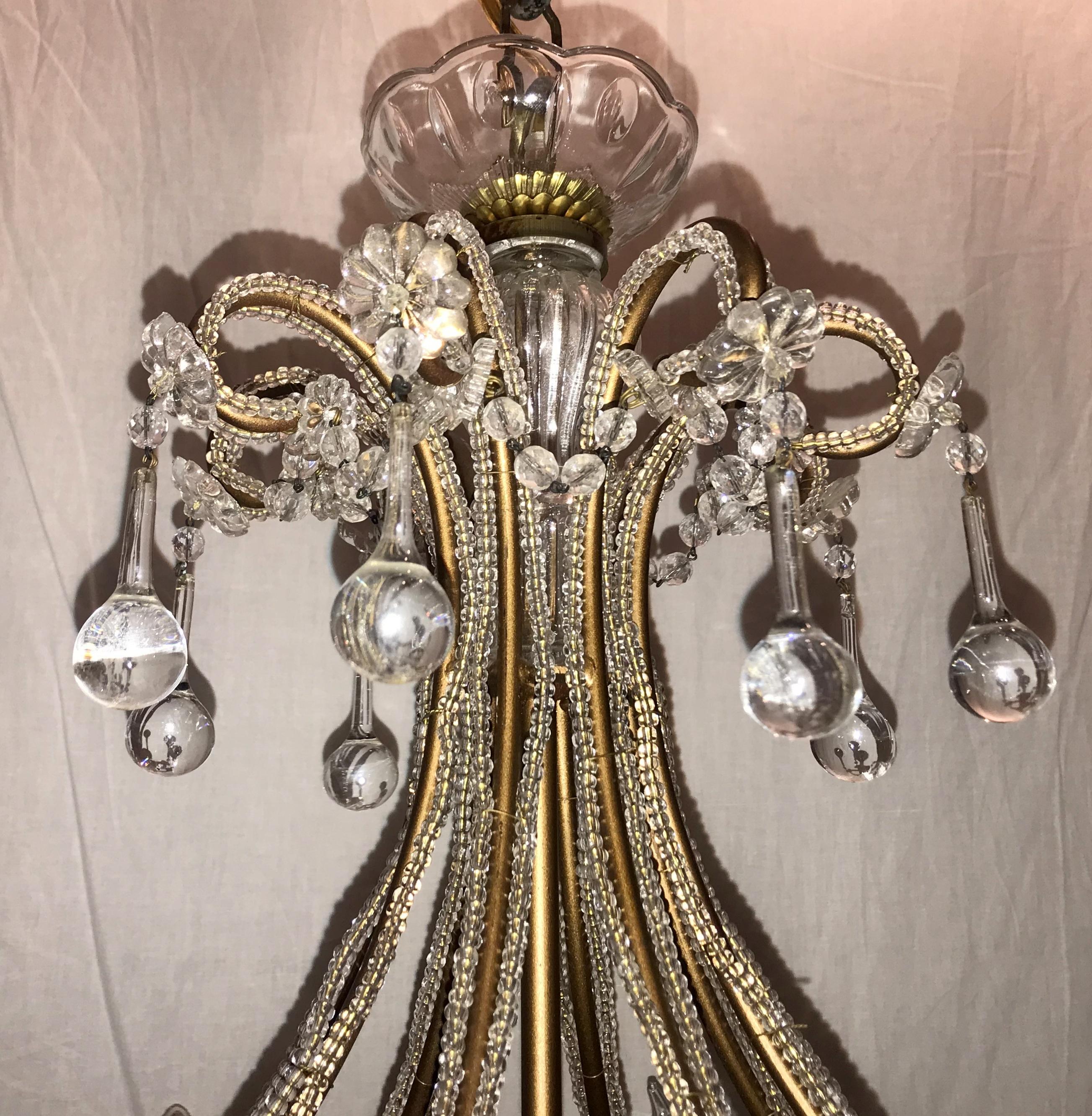 A wonderful Italian Venetian vintage chandelier with beaded crystals throughout the bird cage and beaded swags draped from arm to arm. This beautiful chandelier has eight candelabra lights with tear drops on each of the arms and crystal cups, and is