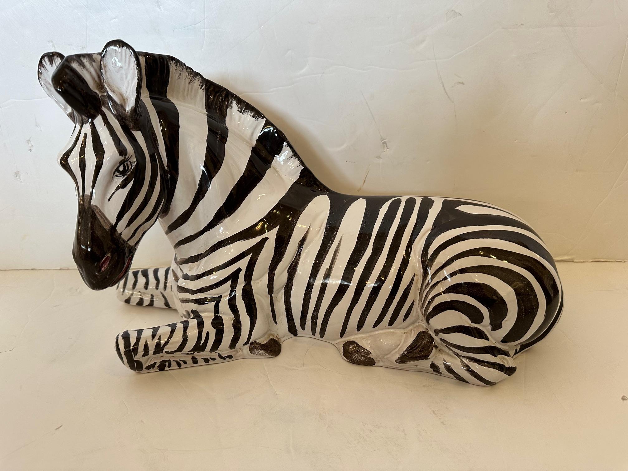 Striking vintage hand painted glazed ceramic zebra sculpture in a charming resting position from Italy.