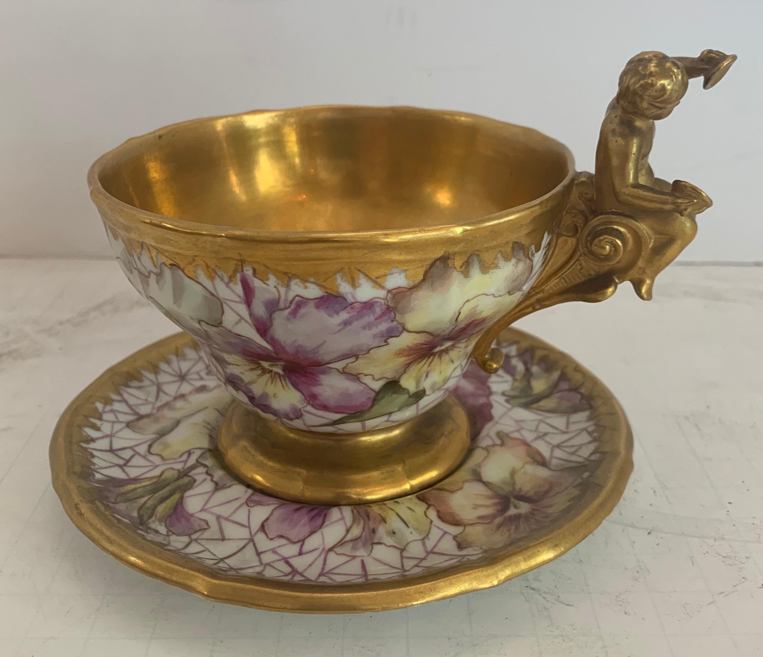 A wonderful KPM hand painted porcelain German cup and saucer set with cherub / putti and flower gold gilt decoration.
