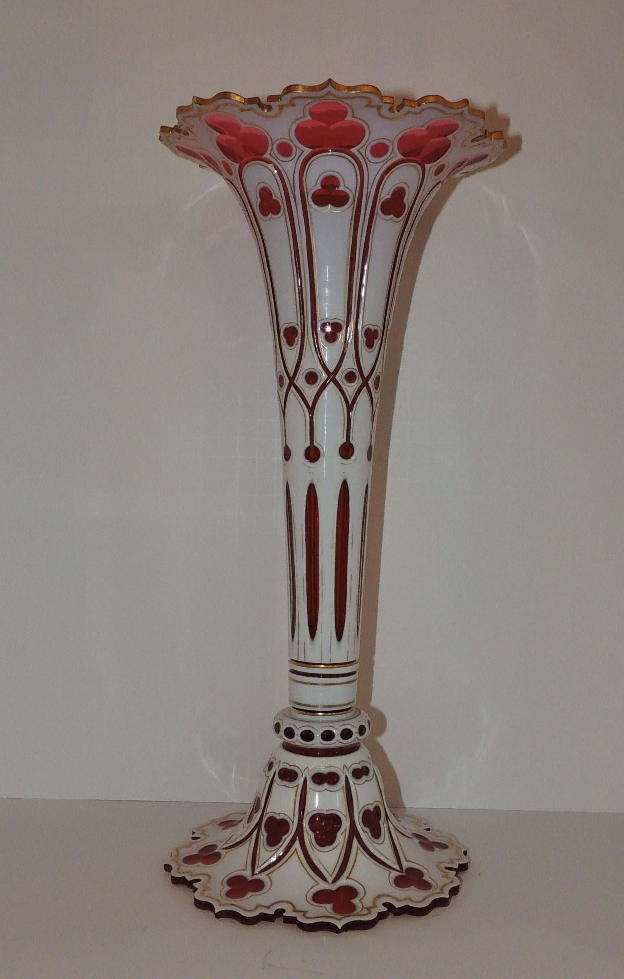 A beautiful red Bohemian cut crystal glass overlay with white and gilt trim in the clover pattern.

Measures: 16.25