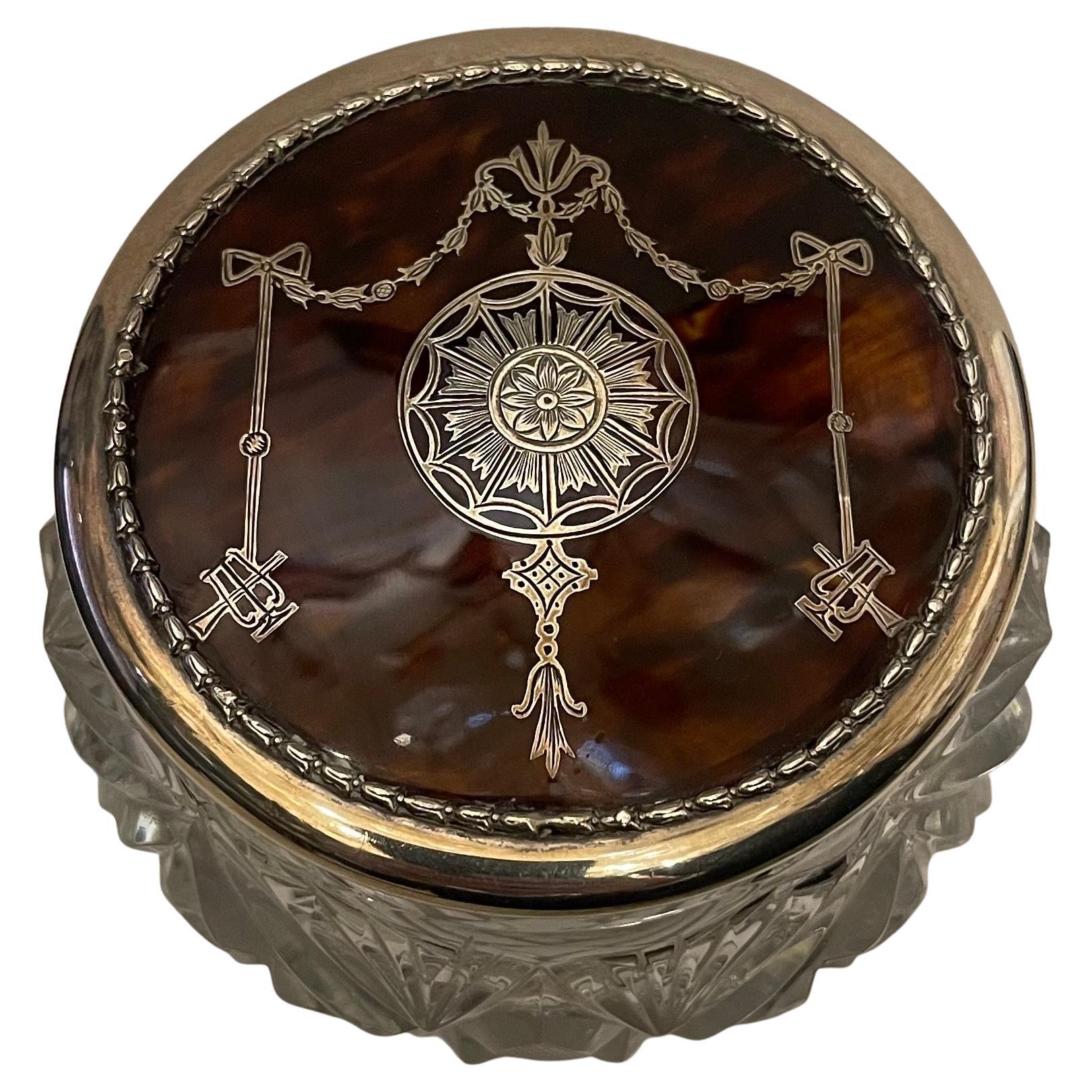 A Wonderful Large Cut Crystal And Sterling Silver With Tortoise Shell Vanity Jar Powder Box.
The Crystal Base Is Of A Deeply Cut Crystal In A Hobnail Or Diamond Cut Pattern. 
The Lid Is Sterling Silver, Hallmarked From London In The 1920's 
The Lid