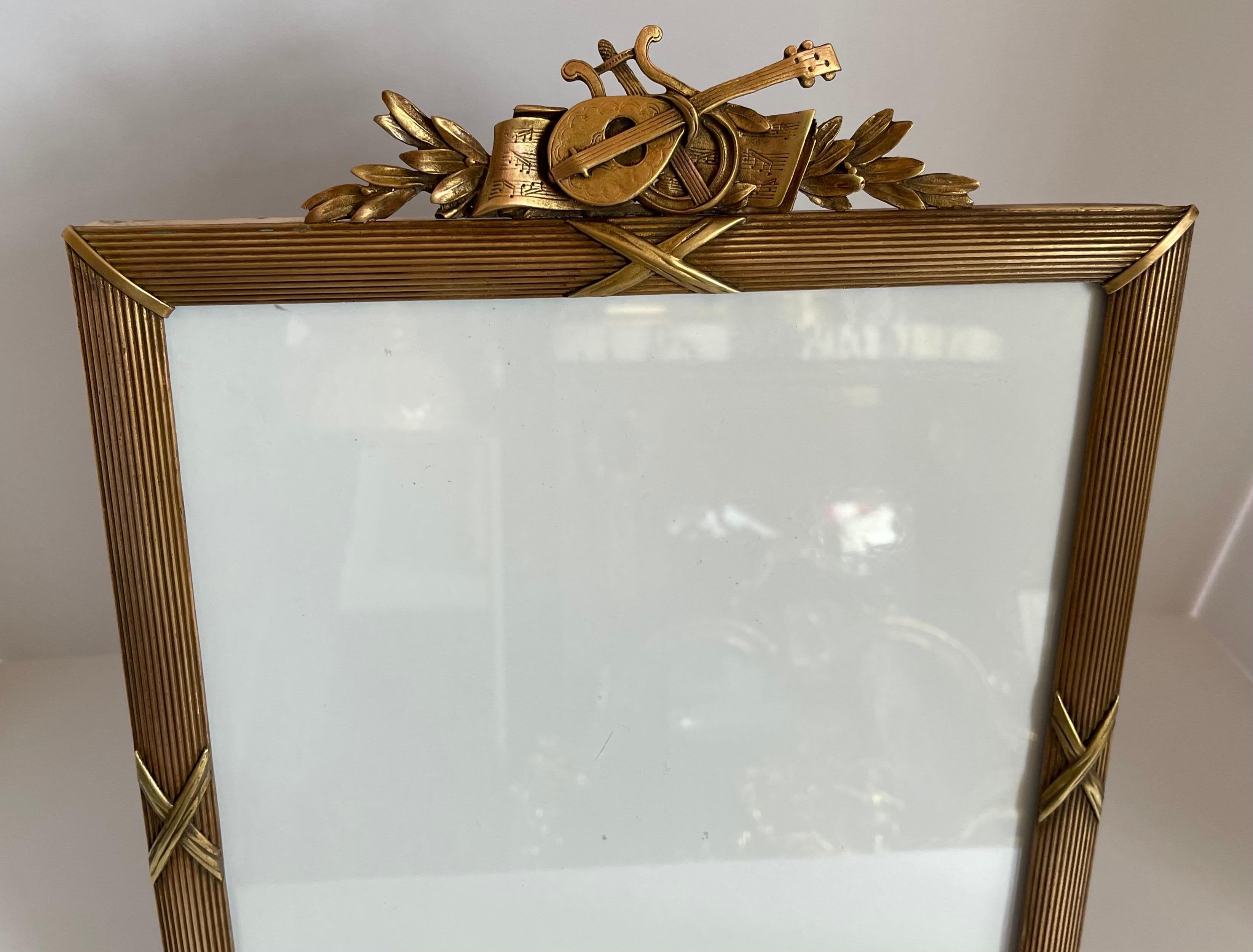 A wonderful large French Louis XVI style gilt bronze picture frame with lute / instruments and garland crown bordered with reed and ribbon frame
Stamped France.